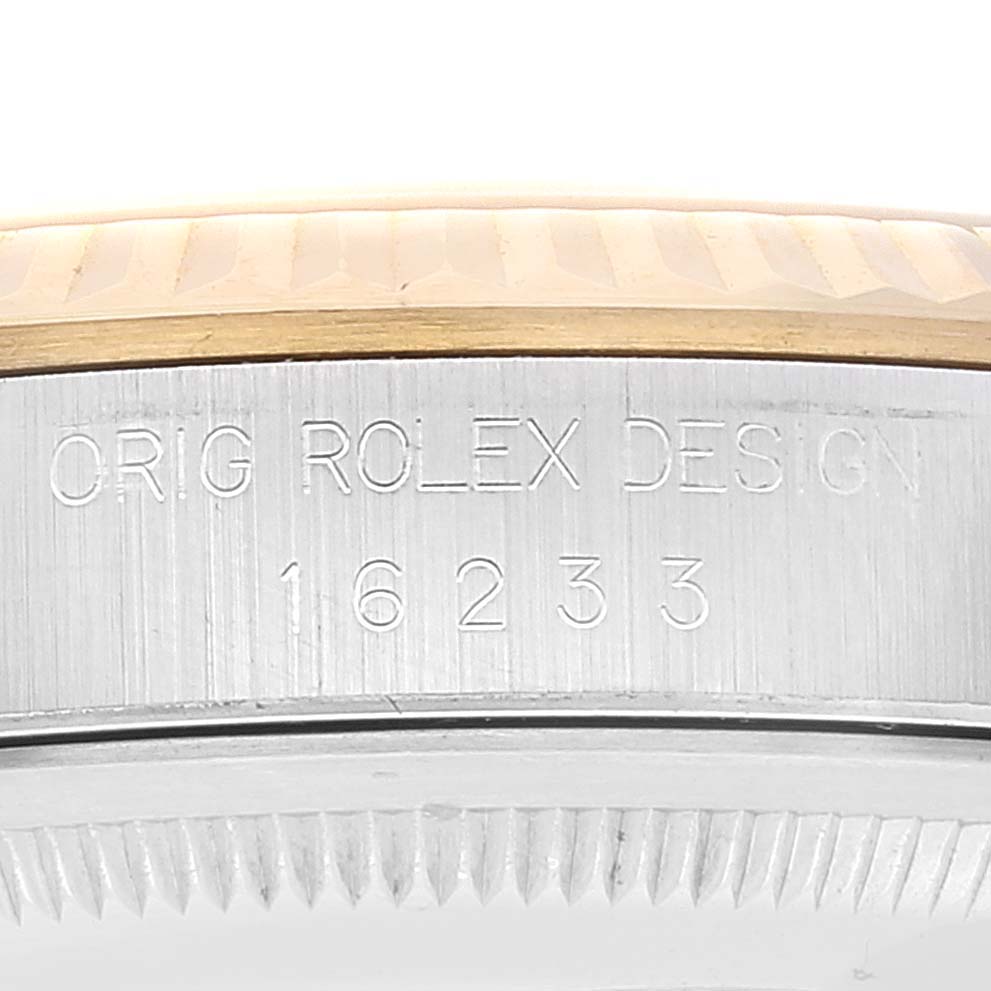 This image shows a close-up of the side of a Rolex Datejust 16233 Men's Steel and Gold (two tone) Champagne Dial 16233 Men's Steel and Gold (two tone) Champagne Dial watch, focusing on its model number and "ORIG ROLEX DESIGN" engraving.
