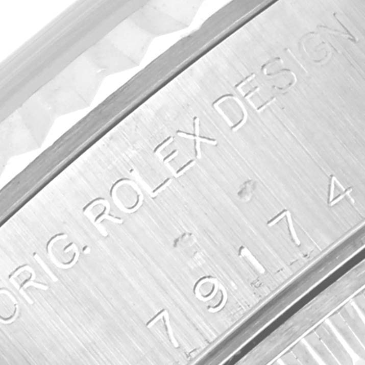 This close-up shows the Rolex Datejust 79174 Women
s Stainless Steel Silver Dial 79174 Women
s Stainless Steel Silver Dial watch
s inner bezel with "ORIG. ROLEX DESIGN" and serial number engraving.