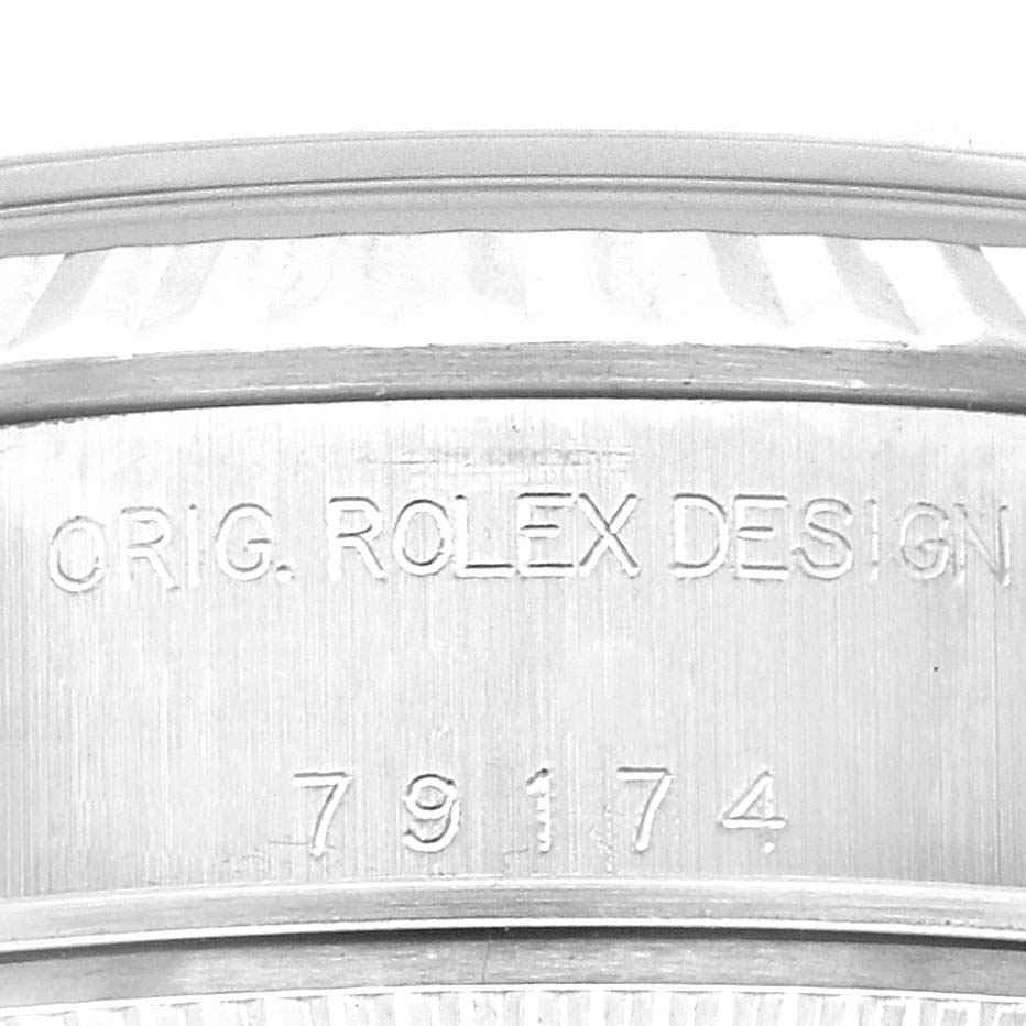 This image shows a close-up of the engraved serial number and "ORIG. ROLEX DESIGN" on the case of a Rolex Datejust 79174 Women
s Stainless Steel Silver Dial 79174 Women
s Stainless Steel Silver Dial watch.