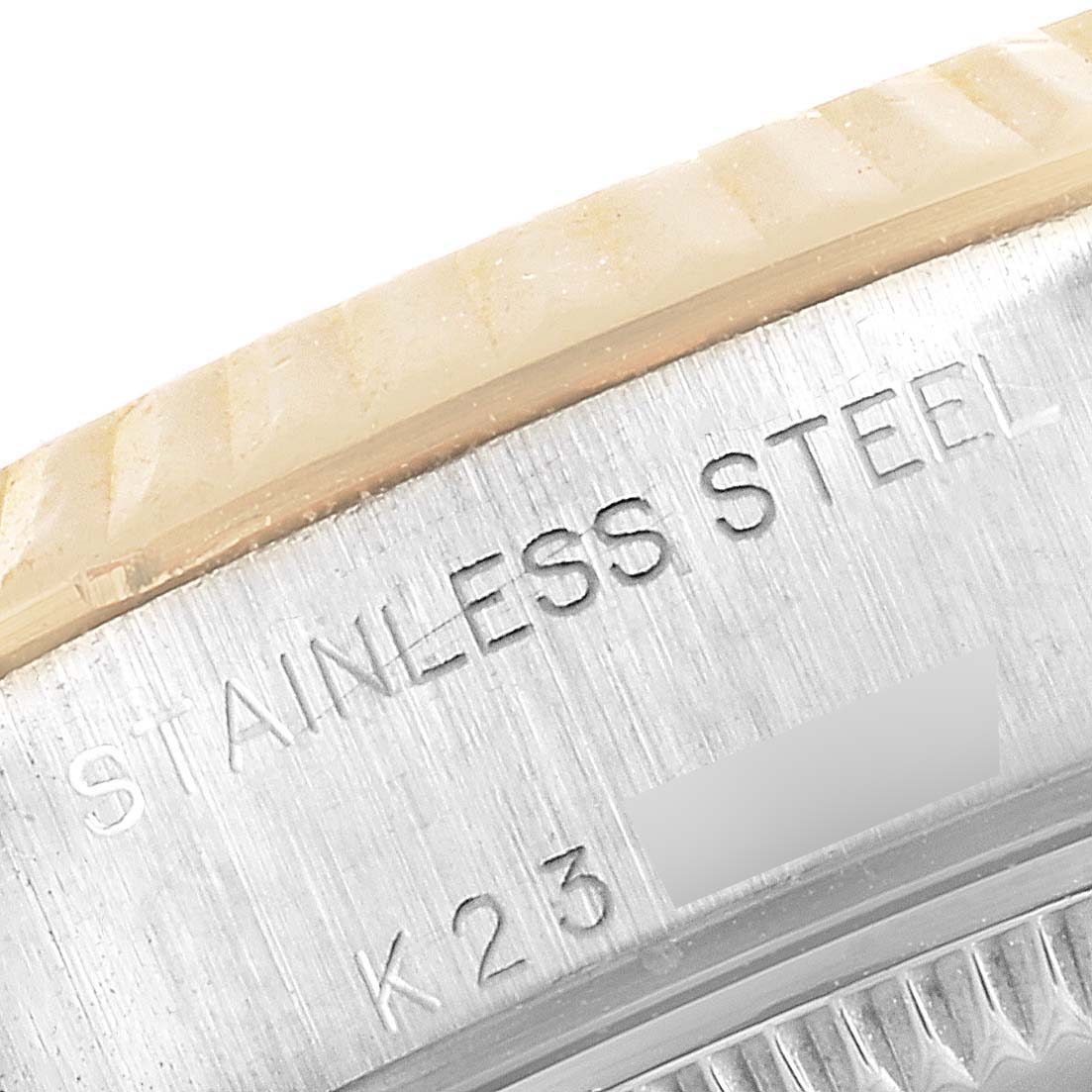 The image shows a close-up of the edge and engraved markings on a Rolex Datejust 79173 Women's Steel and Gold (two tone) Silver Dial 79173 Women's Steel and Gold (two tone) Silver Dial model stainless steel watch case.