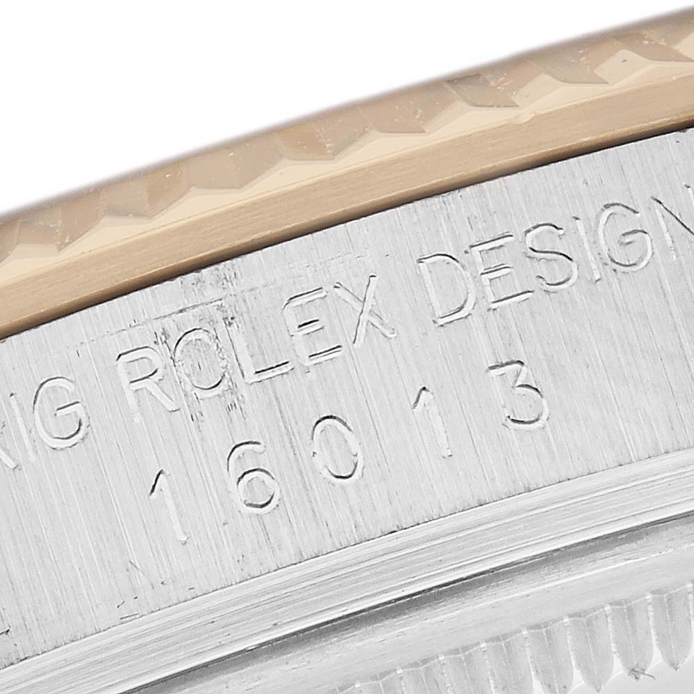 The image shows the side of a Rolex Datejust 16013 Men
s Steel and Gold (two tone) Champagne Dial 16013 Men
s Steel and Gold (two tone) Champagne Dial watch, highlighting the case with engraved text and partial bezel visible.