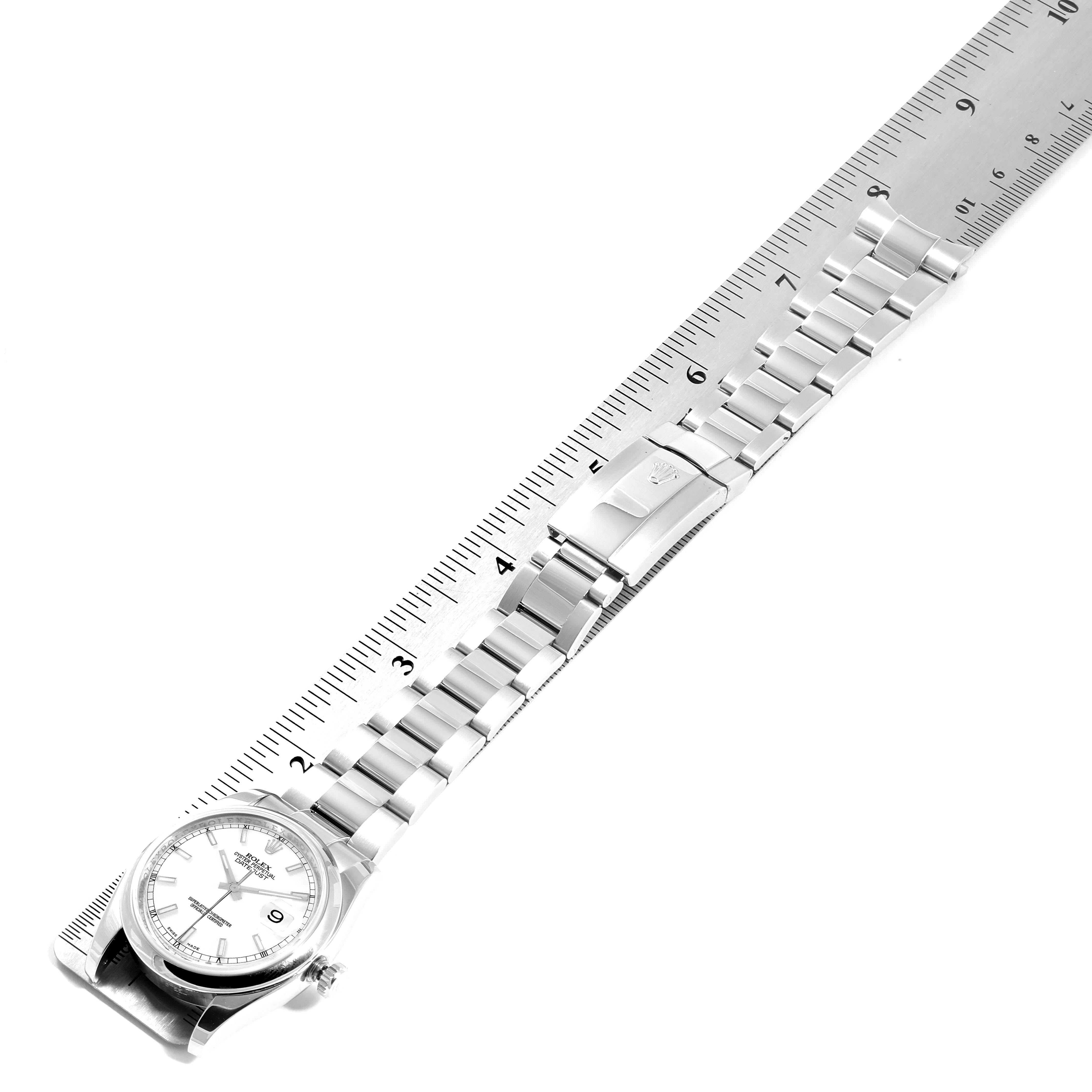 The Rolex Datejust 116200 Men's Stainless Steel White Dial 116200 Men's Stainless Steel White Dial watch is shown flat with a focus on the full length of its bracelet and clasp, alongside a ruler for measurement.