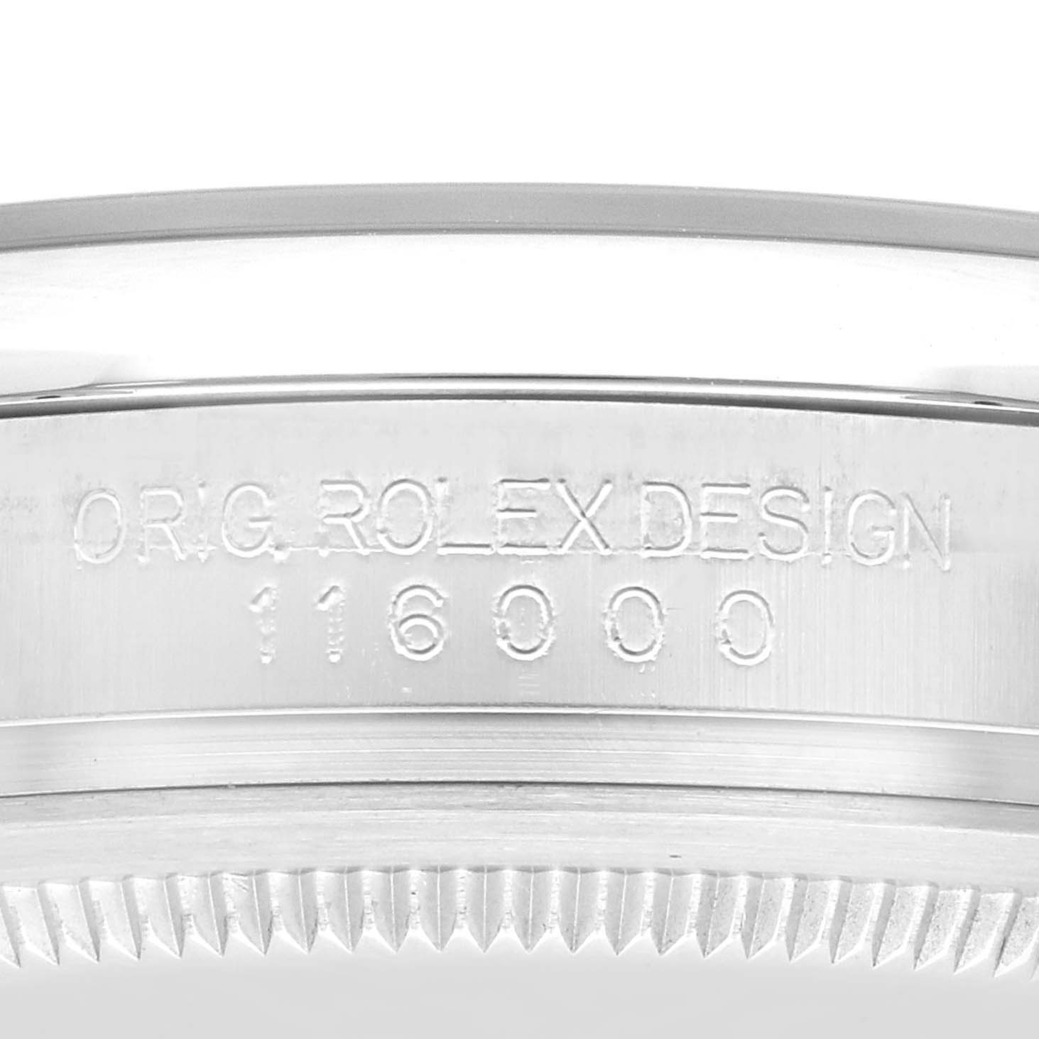 This image showcases the side of a Rolex Oyster Perpetual 116000 Men
s Stainless Steel Blue Dial 116000 Men
s Stainless Steel Blue Dial watch with its model number "116000" and "ORIG. ROLEX DESIGN" engraving.