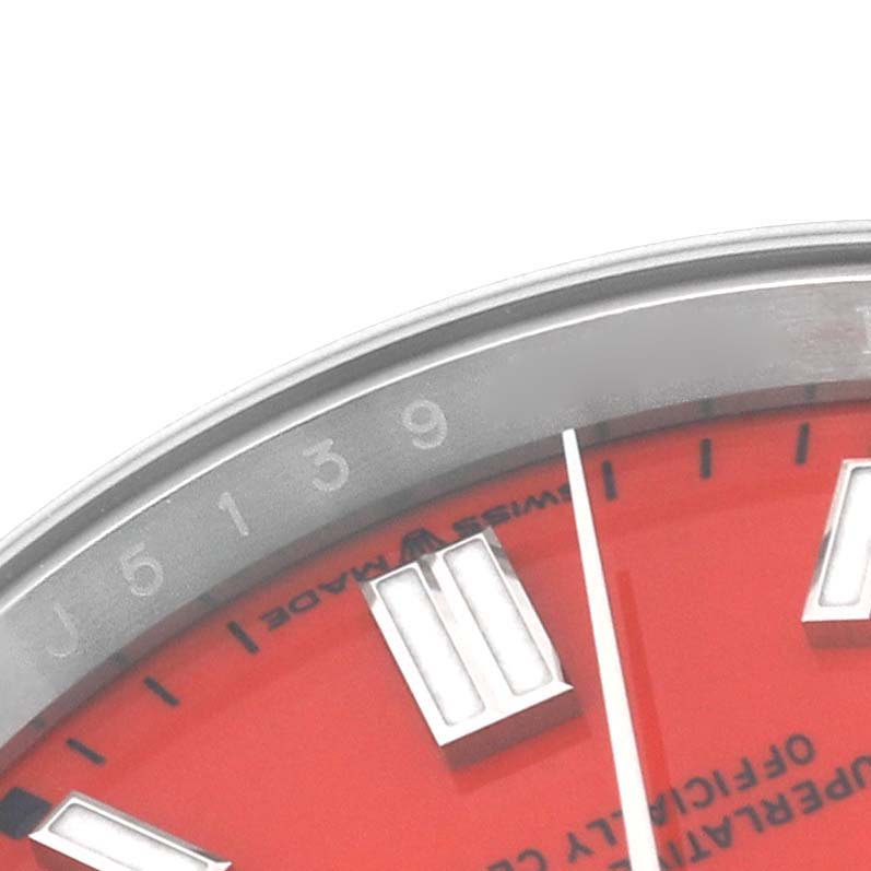 This image shows a close-up of the upper portion of the red dial and part of the bezel of the Rolex Oyster Perpetual 126000 Men's Stainless Steel Red Dial 126000 Men's Stainless Steel Red Dial watch.