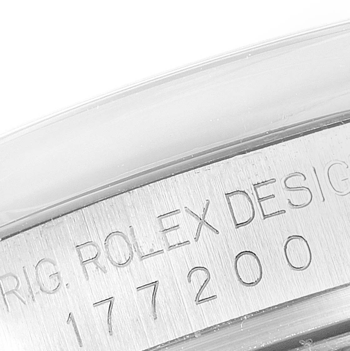 This image shows a close-up of the side engraving of a Mid-Size Rolex watch, displaying part of its serial number and design details.