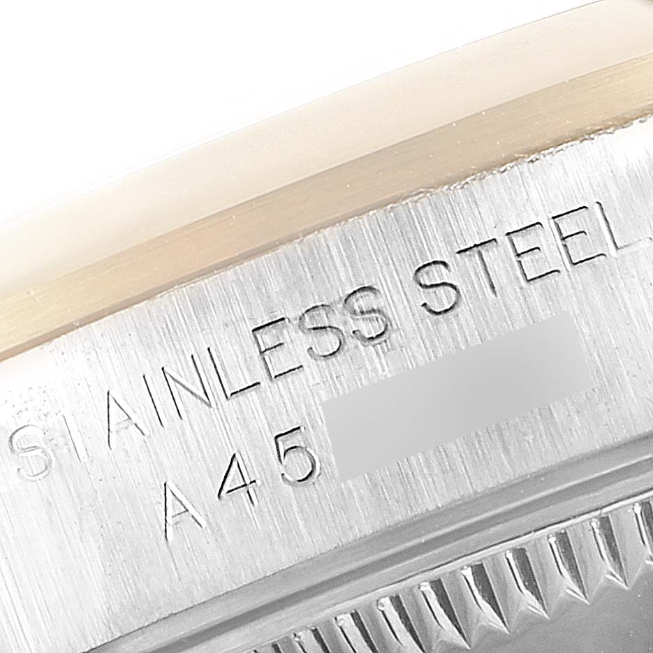 This image shows a close-up of the case back engraving on a Rolex Oyster Perpetual 76183 Women's Steel and Gold (two tone) Grey Dial 76183 Women's Steel and Gold (two tone) Grey Dial watch, highlighting "STAINLESS STEEL" and a serial number.