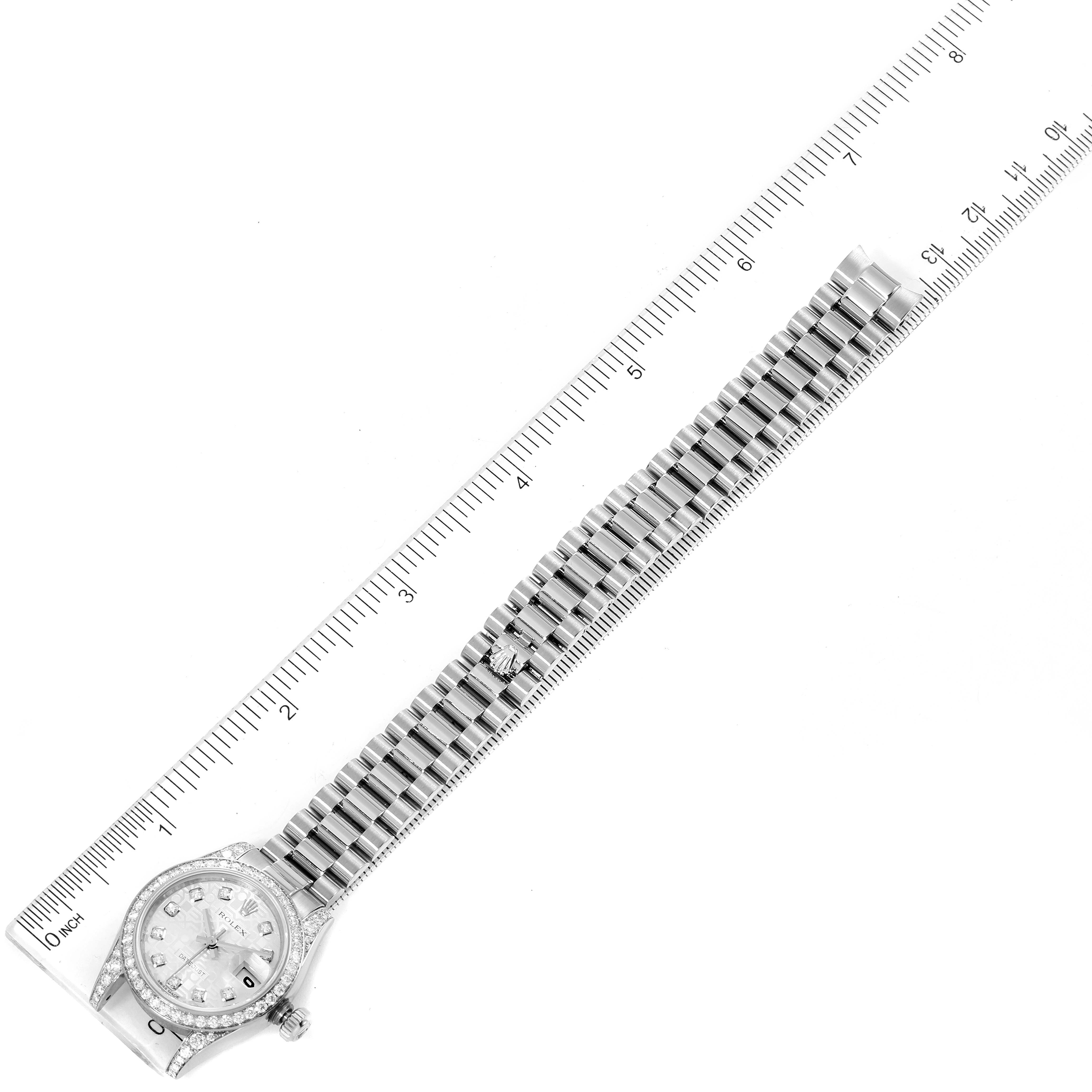 This image shows an overhead view of a Rolex President 179159 Women's White Gold Silver Dial 179159 Women's White Gold Silver Dial model watch placed alongside a ruler for measurement.
