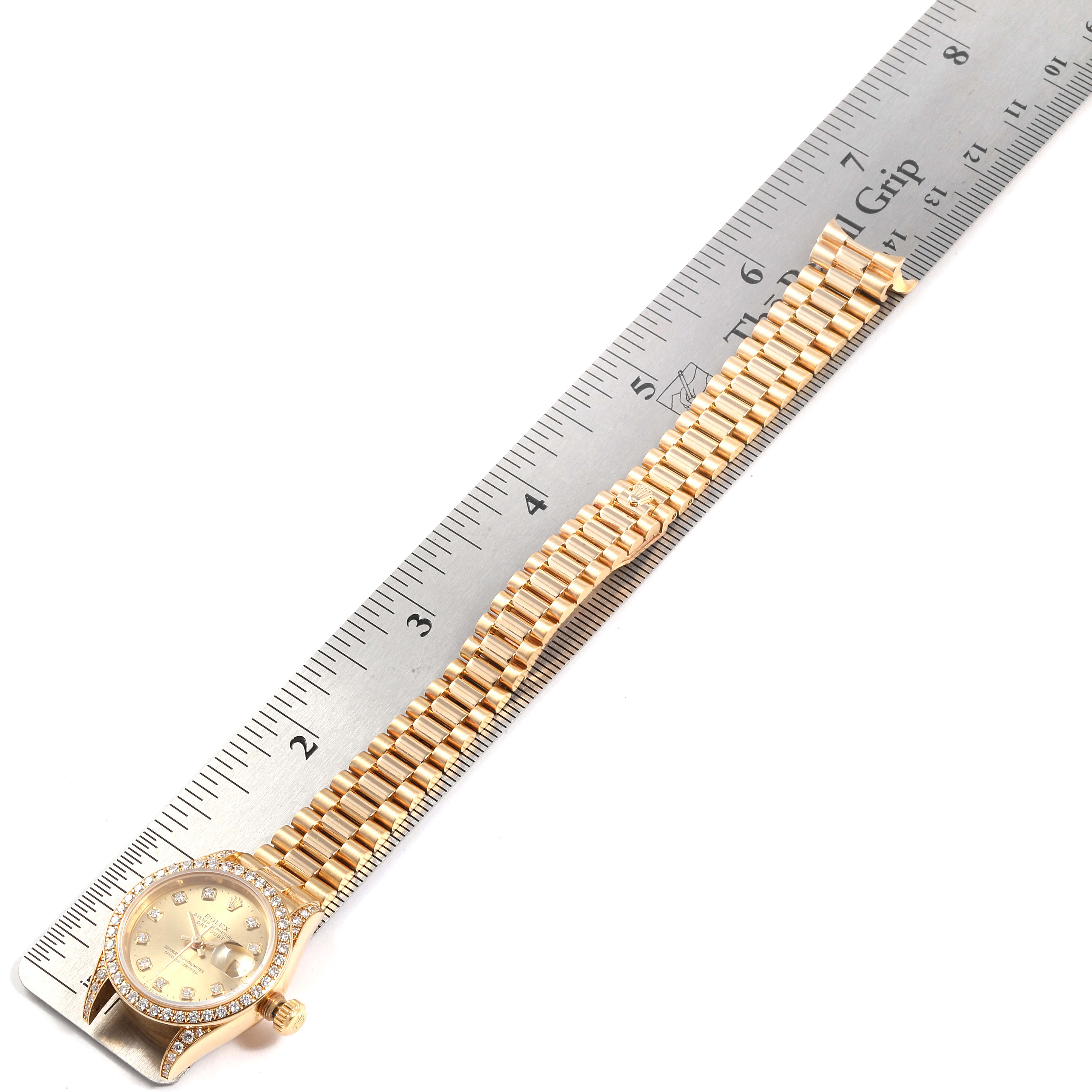 The image shows a Rolex President 69238 Women's Yellow Gold Champagne Dial 69238 Women's Yellow Gold Champagne Dial model watch laid flat next to a ruler, displaying the face, bezel, and full bracelet.