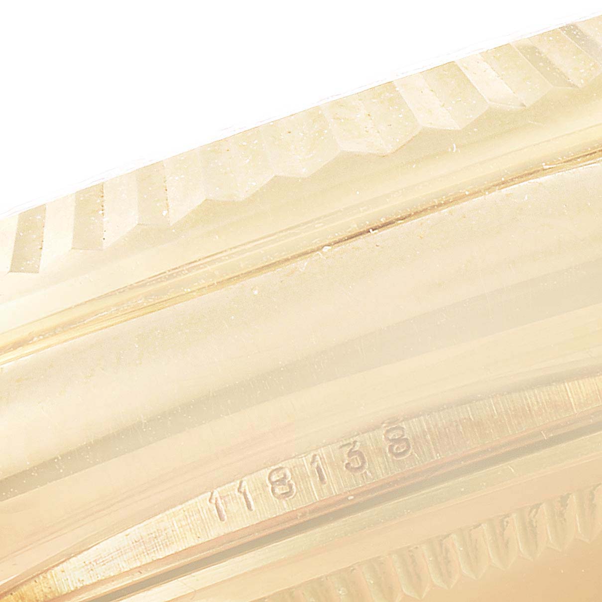 This image shows a close-up of the bezel and part of the case of a Rolex President 118138 Men's Yellow Gold Green Dial 118138 Men's Yellow Gold Green Dial model watch.