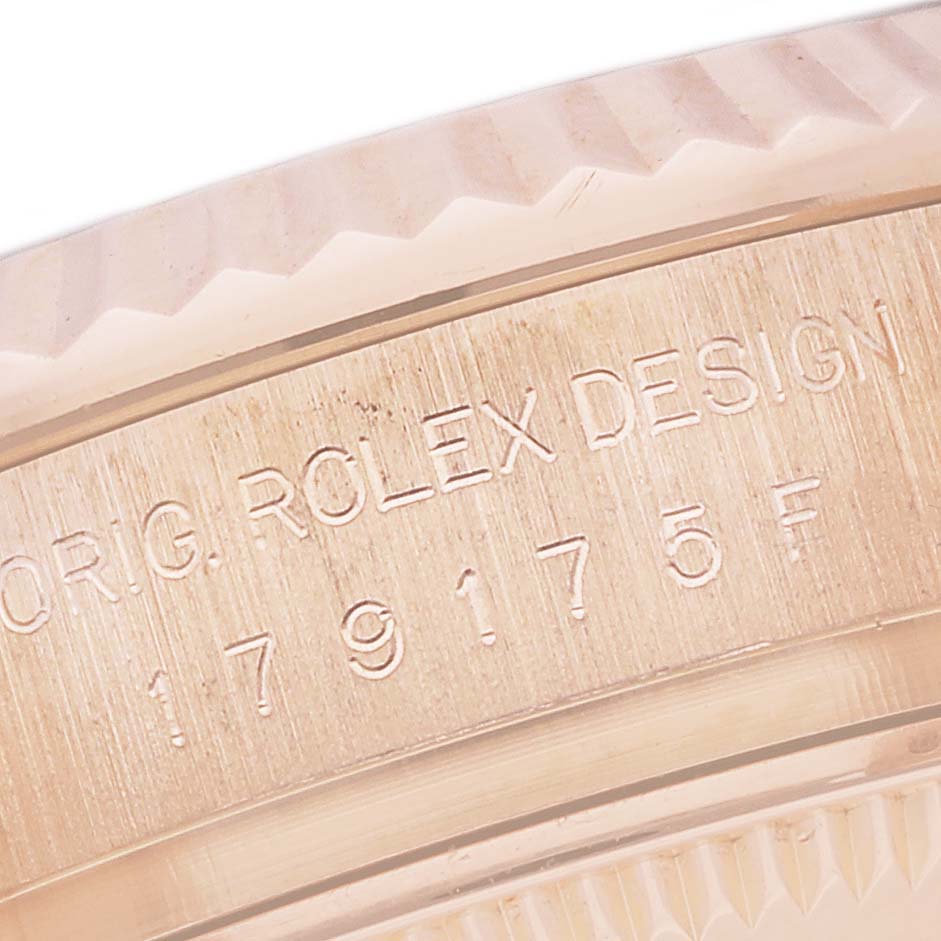 The image shows a close-up of the engraved outer edge, or bezel, of a Rolex President 179175F Women's Rose Gold Mother of Pearl Dial 179175F Women's Rose Gold Mother of Pearl Dial model watch with text detailing the brand and design.