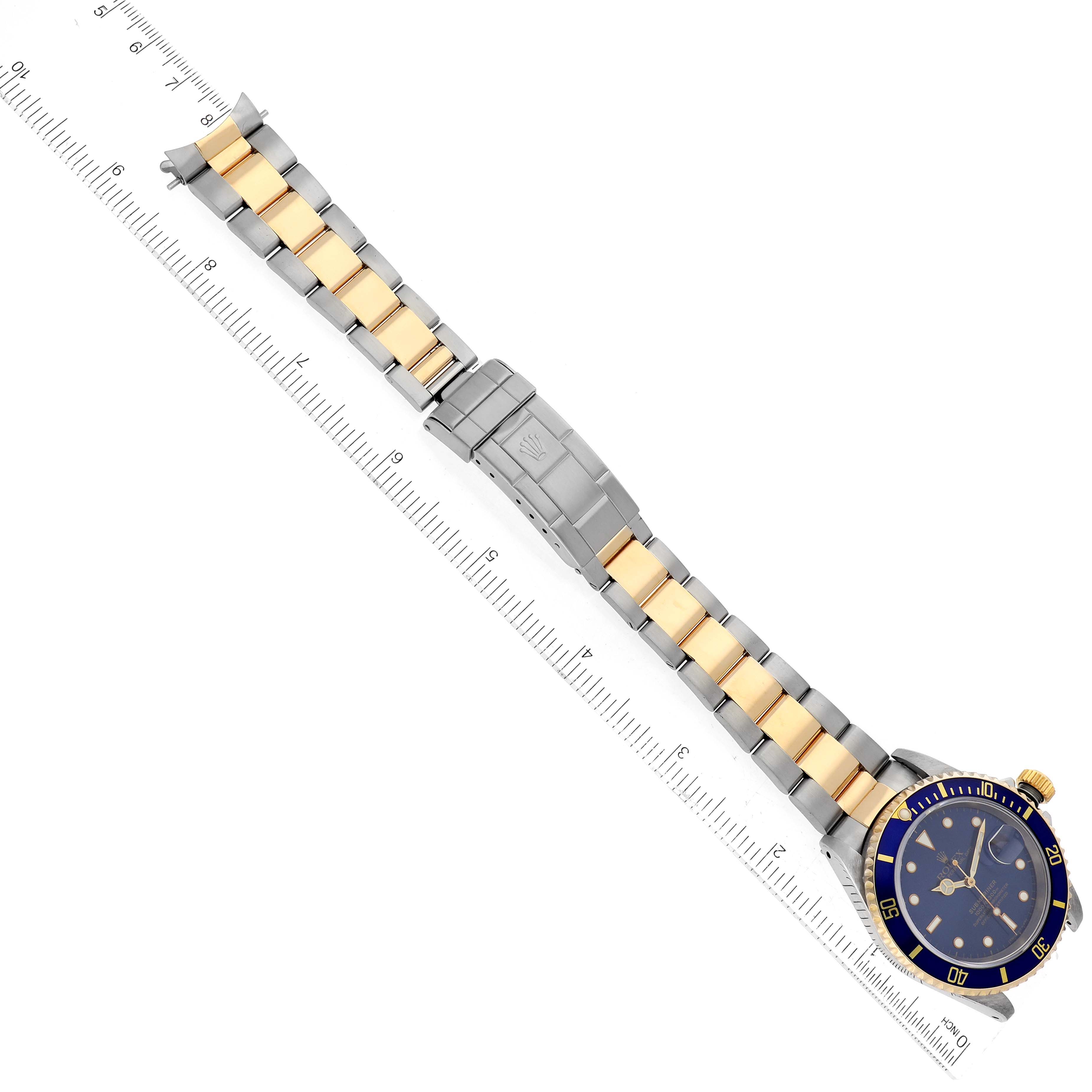 The image shows the Rolex Submariner 16613 Men's Steel and Gold (two tone) Blue Dial 16613 Men's Steel and Gold (two tone) Blue Dial watch lying flat, highlighting its bracelet, clasp, and dial.