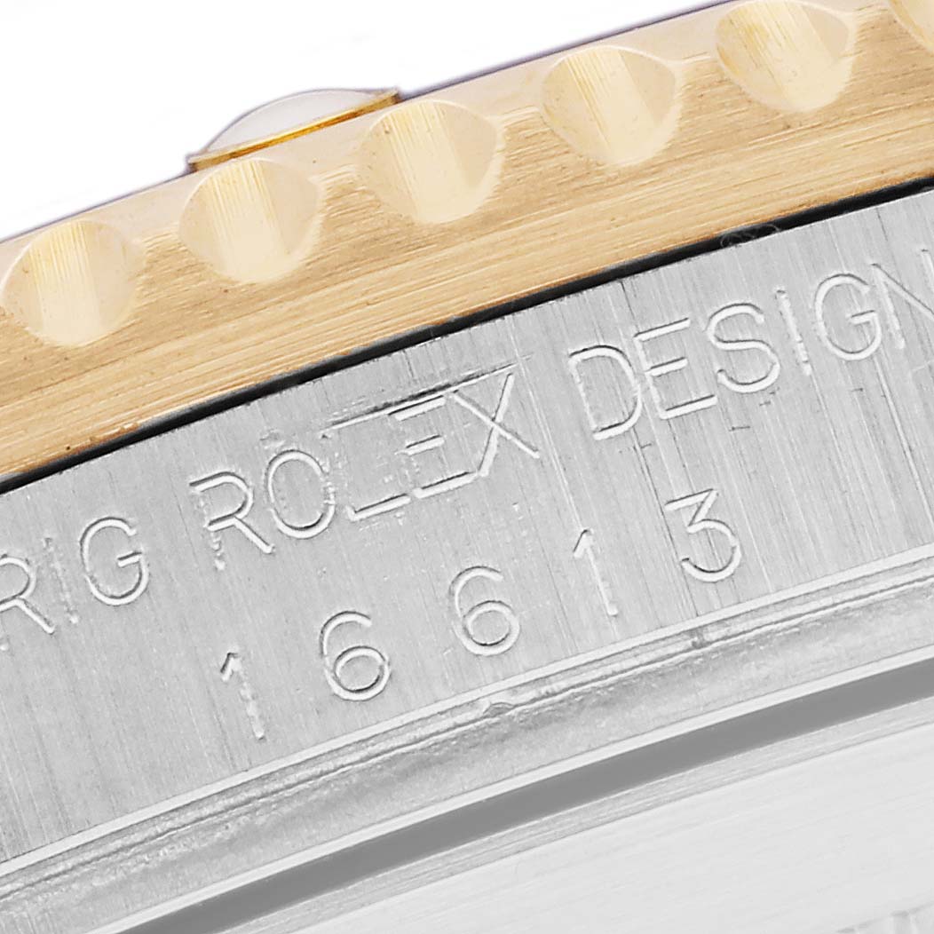 The image shows a close-up of the engraved side case and bezel of a Rolex Submariner 16613 Men's Steel and Gold (two tone) Blue Dial 16613 Men's Steel and Gold (two tone) Blue Dial watch.