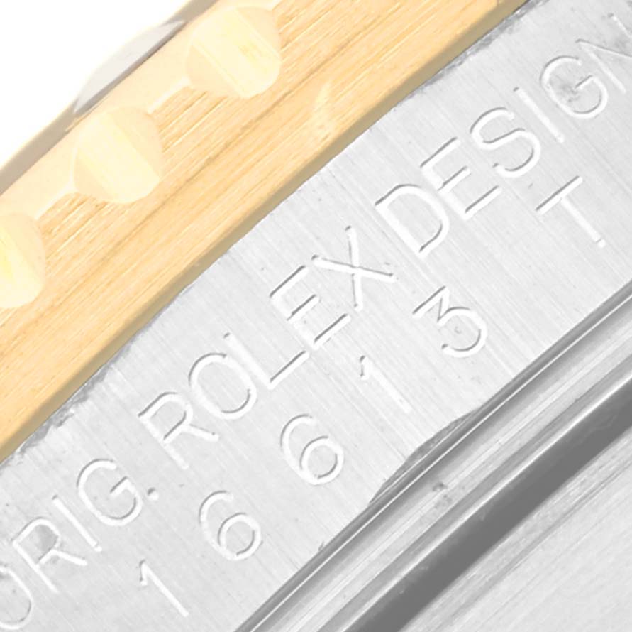 This image shows a close-up of the engraving on the side of a Rolex Submariner 16613LN Men's Steel and Gold (two tone) Mother of Pearl Dial 16613LN Men's Steel and Gold (two tone) Mother of Pearl Dial watch case.
