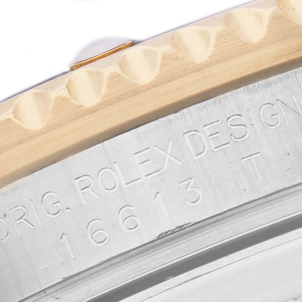 The image shows a close-up of the bezel and engraved side of a Rolex Submariner 16613 Men
s Steel and Gold (two tone) Blue Dial 16613 Men
s Steel and Gold (two tone) Blue Dial watch.