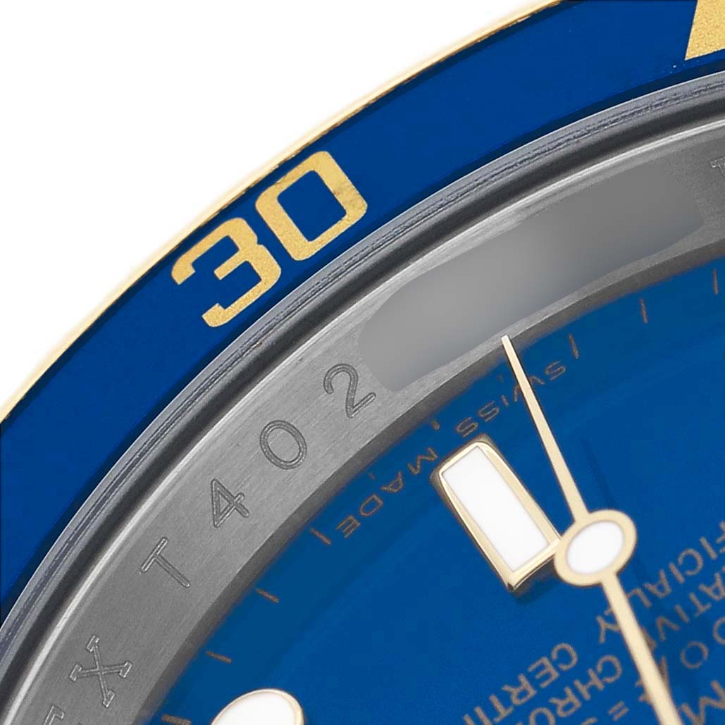This image is a close-up shot showing part of the bezel and dial of a Rolex Submariner 16613 Men's Steel and Gold (two tone) Blue Dial, highlighting the blue and gold details.