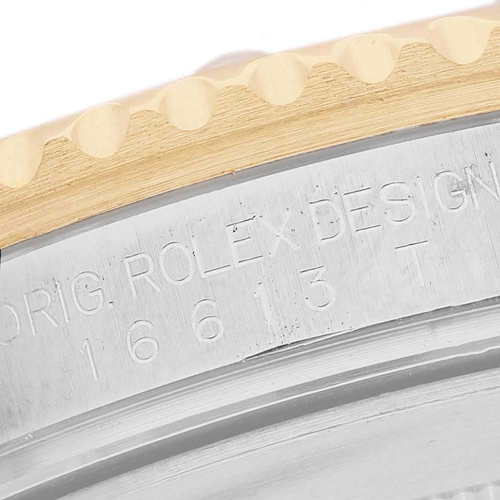 The image shows a close-up of the engraved side of a Rolex Submariner 16613 Men's Steel and Gold (two tone) Blue Dial watch, highlighting the edge of the bezel and case serial details.