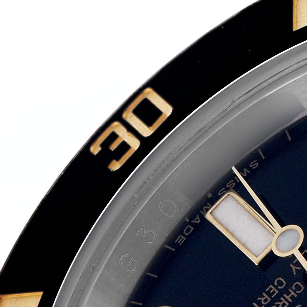 The image shows a close-up of the bezel and part of the dial of a Rolex Submariner 116613 Men
s Steel and Gold (two tone) Black Dial 116613 Men
s Steel and Gold (two tone) Black Dial, featuring the "30" minute marker.