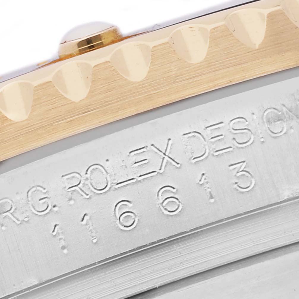 The image shows a close-up of the bezel edge and engraved casing of a Rolex Submariner 116613 Men
s Steel and Gold (two tone) Black Dial 116613 Men
s Steel and Gold (two tone) Black Dial model.