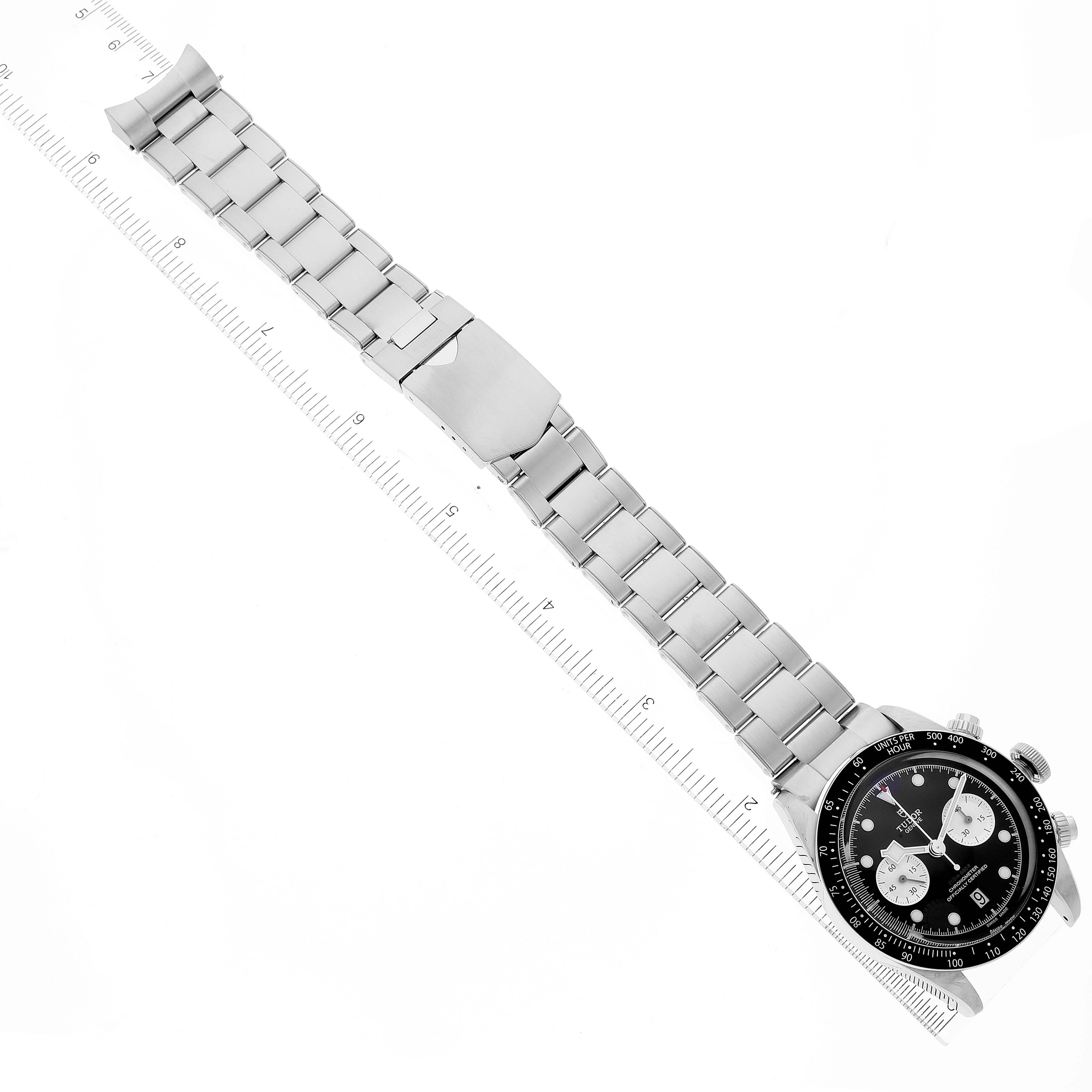 The image shows the Tudor Heritage Chrono 79360N Men's Stainless Steel Black Dial 79360N Men's Stainless Steel Black Dial watch from a top-down angle, displaying its stainless steel bracelet and clasp alongside a ruler for scale.