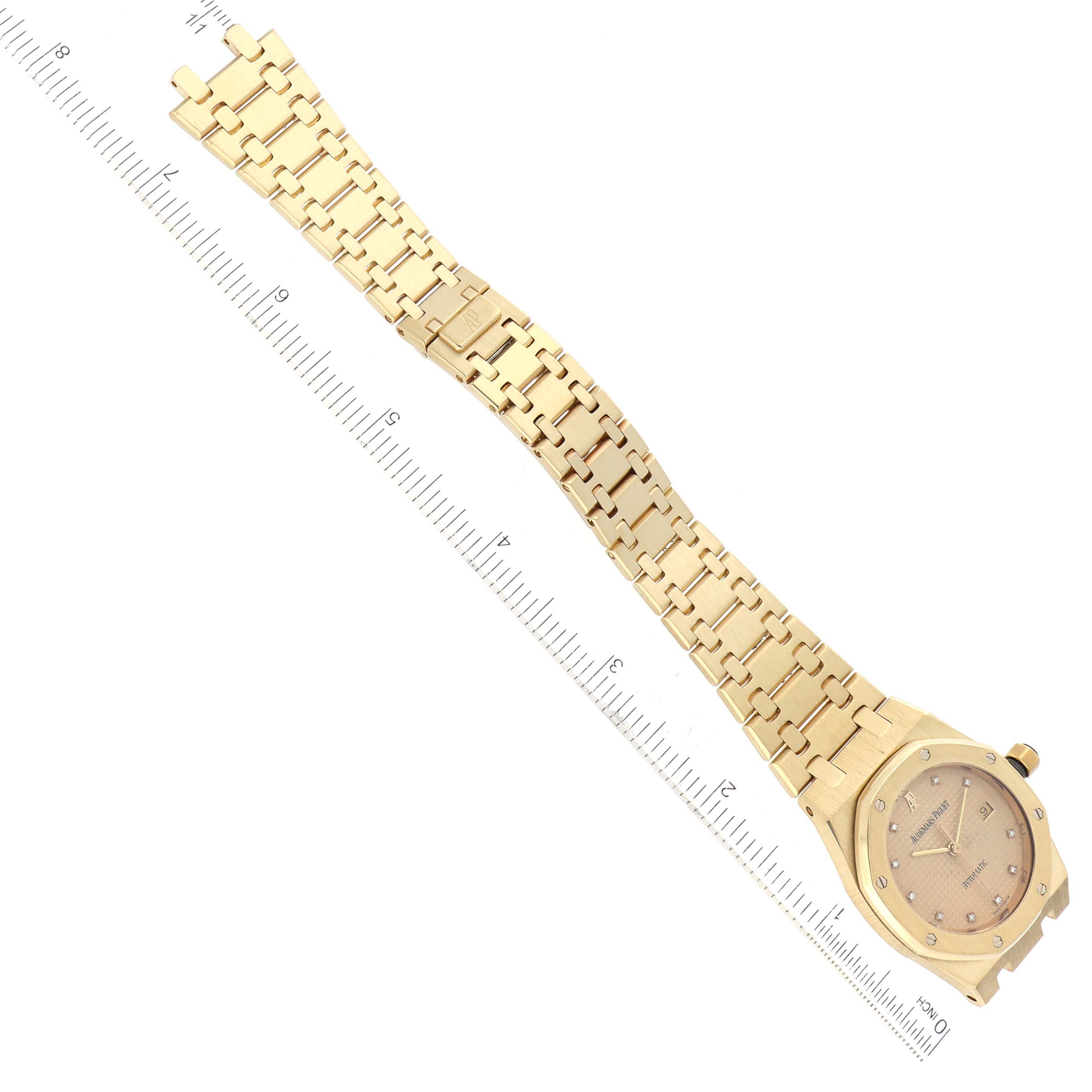 The image shows the full front view of an Audemars Piguet Royal Oak 15000BA.OO.0789BA.04 Men's Yellow Gold Champagne Dial 15000BA.OO.0789BA.04 Men's Yellow Gold Champagne Dial watch, including the dial, bracelet, and clasp, measured against a ruler.