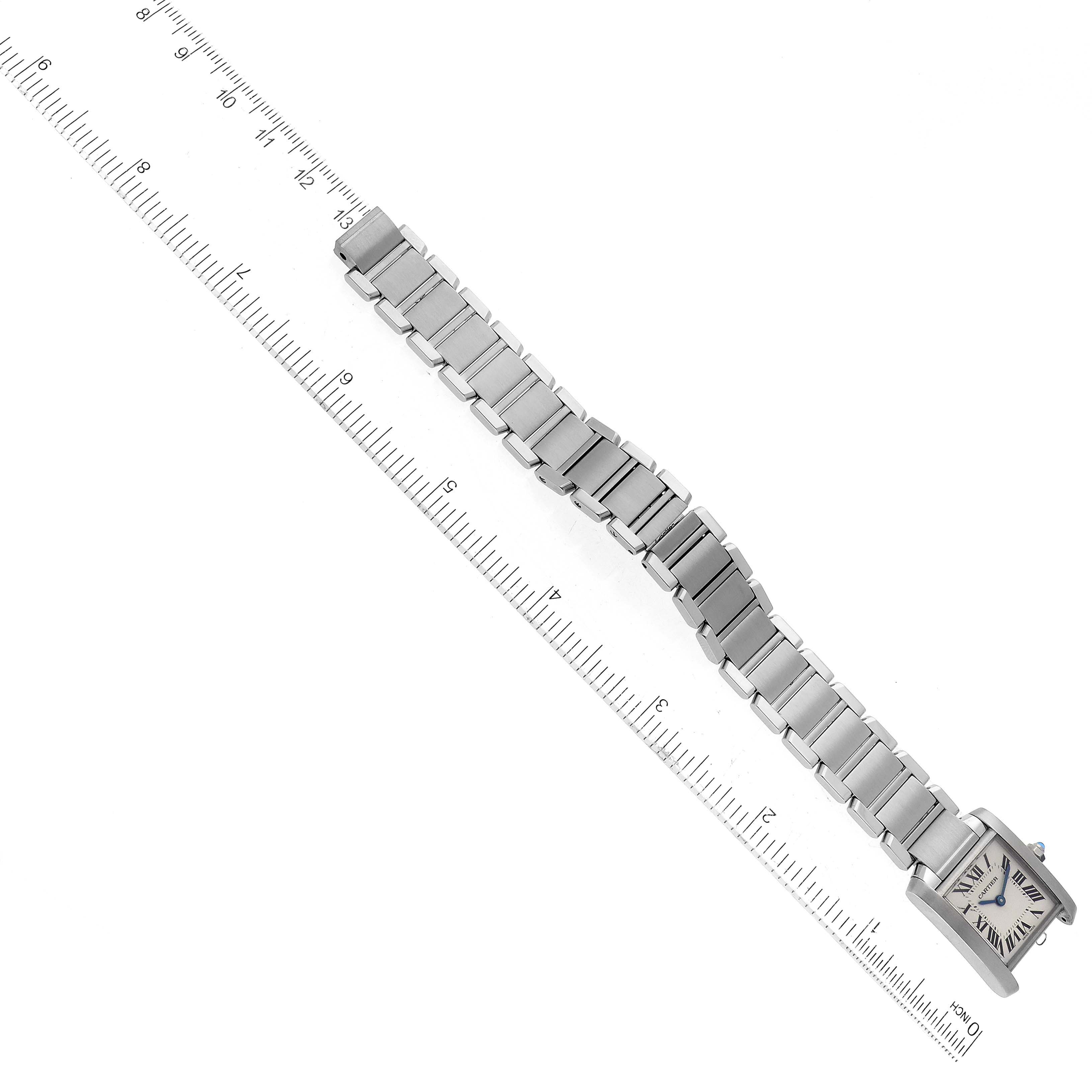 This image shows a top-down view of the Cartier Tank Française watch with the full bracelet extending diagonally next to a ruler.