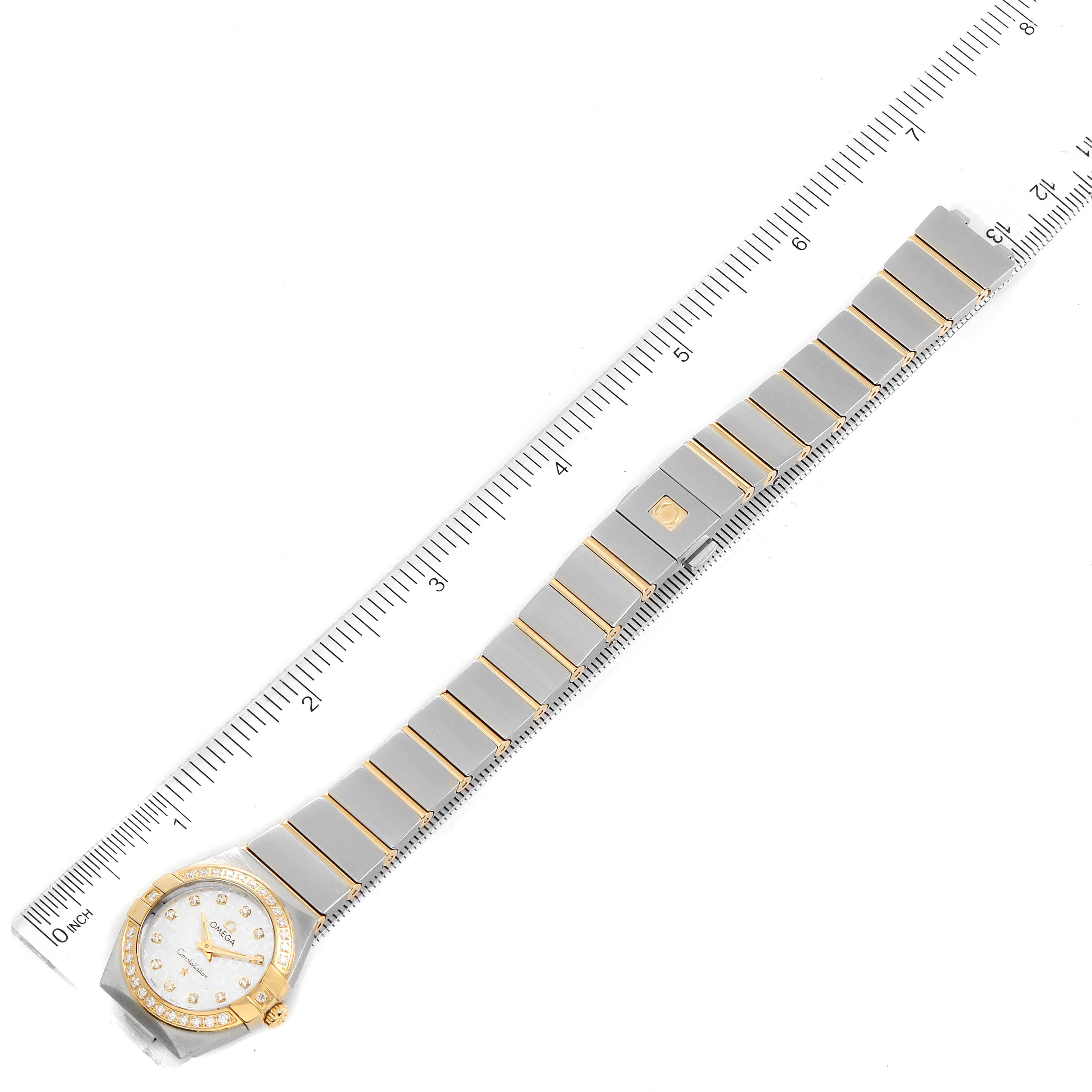 The image shows an overhead view of the Omega 123.25.24.60.52.001 Women's Steel and Gold (two tone) Silver Dial 123.25.24.60.52.001 Women's Steel and Gold (two tone) Silver Dial Constellation Steel Yellow Gold Diamond Ladies Watch 123.25.24.60.52.001 with a ruler for scale.