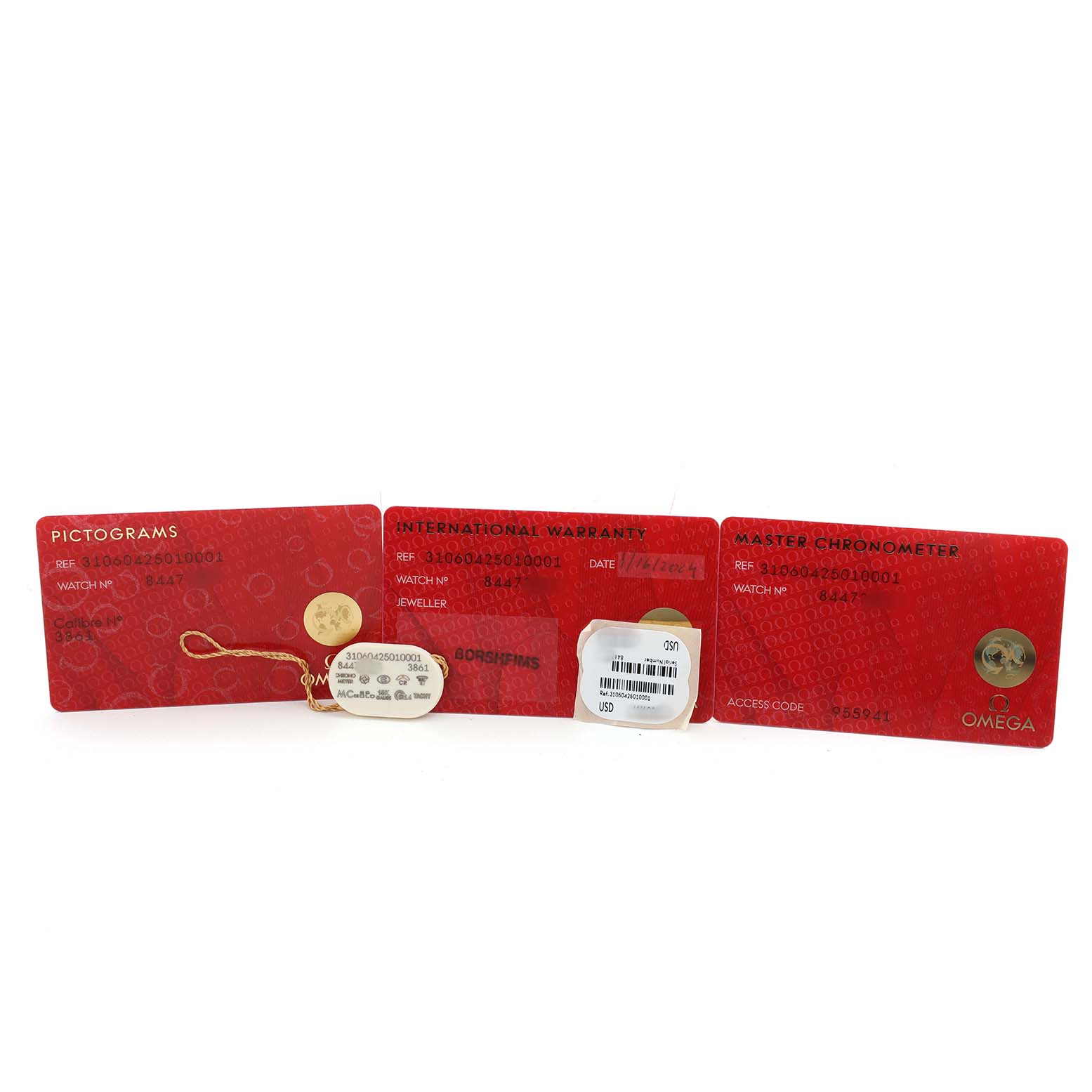 The image shows warranty and certification cards for the Omega Speedmaster 310.60.42.50.10.001 Men's Yellow Gold Green Dial, photographed from above.