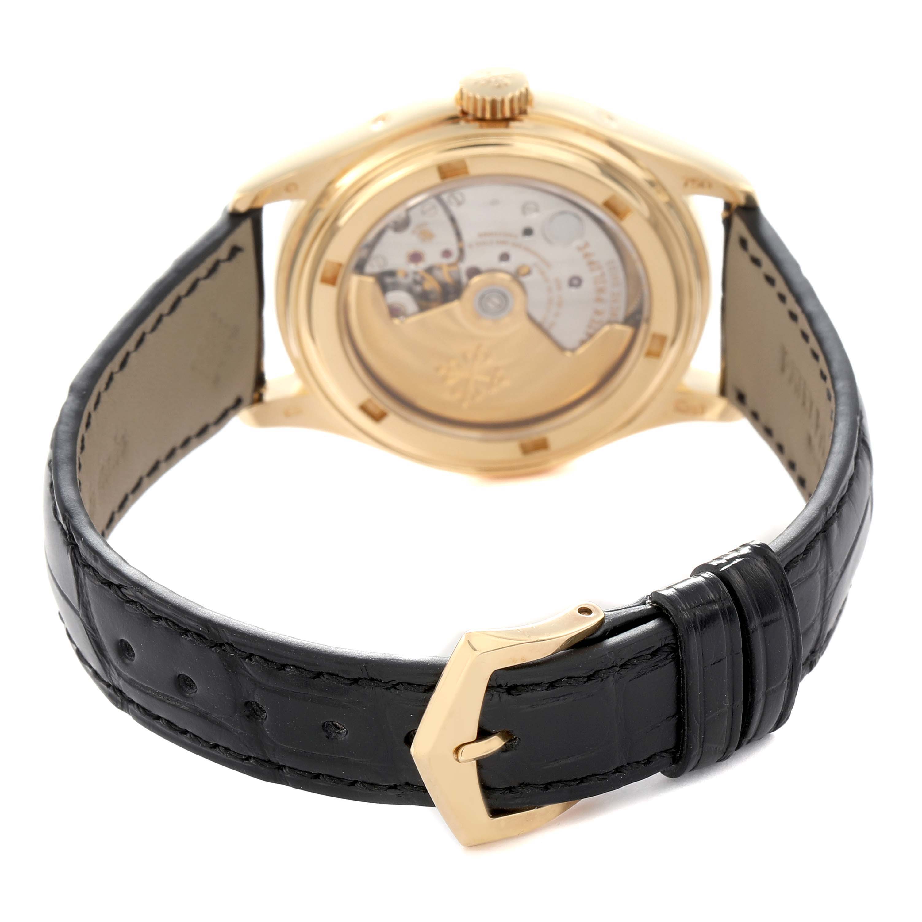 The Patek Philippe Complications 5035J-001 Men's Yellow Gold White Dial 5035J-001 Men's Yellow Gold White Dial watch is shown from the back, highlighting the movement, gold case, and black leather strap.