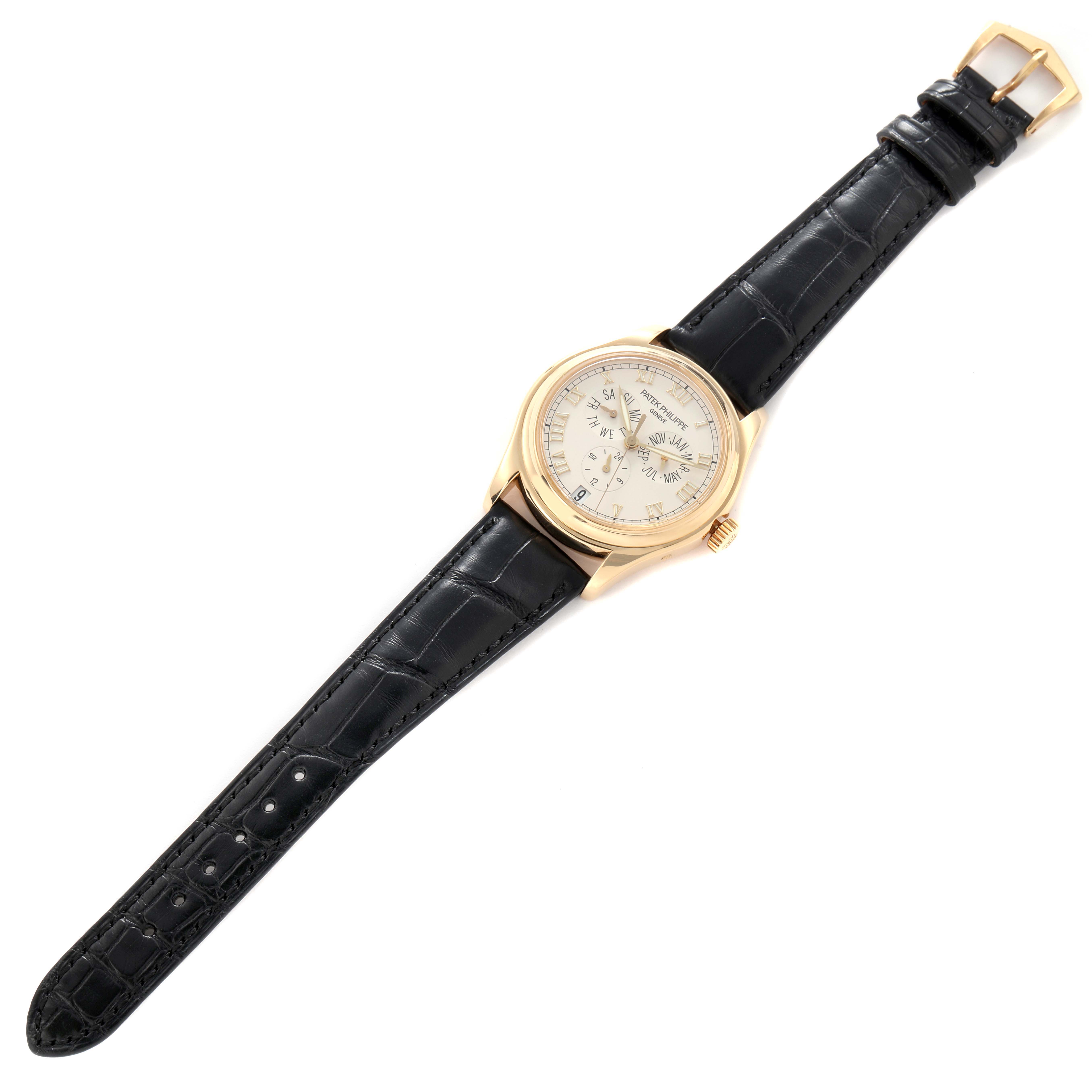 The Patek Philippe Complications 5035J-001 Men's Yellow Gold White Dial 5035J-001 Men's Yellow Gold White Dial watch is shown from a top-down angle, displaying the face, case, and black leather strap.