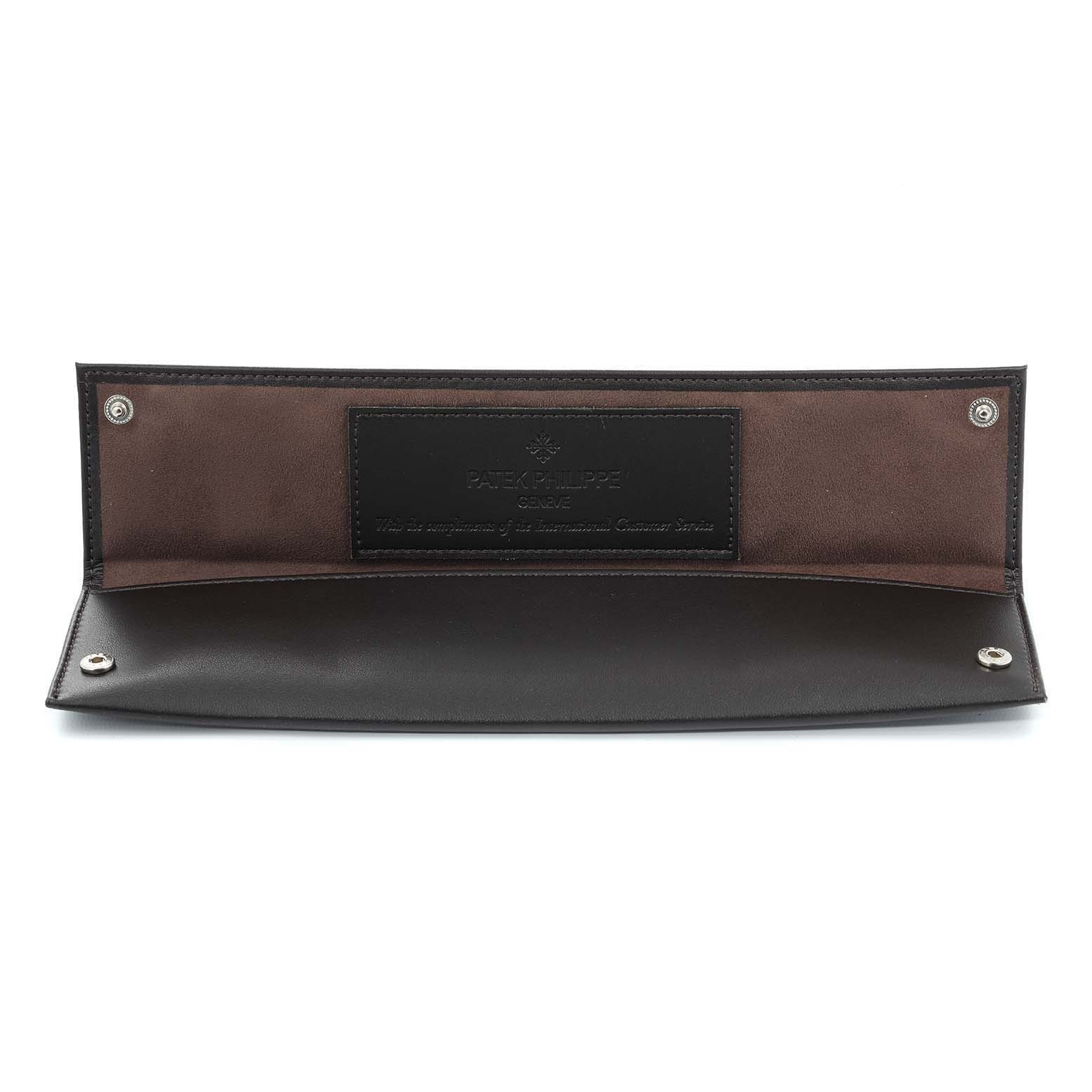 The image shows an open leather watch pouch, branded Patek Philippe, likely for storing the Calatrava model.