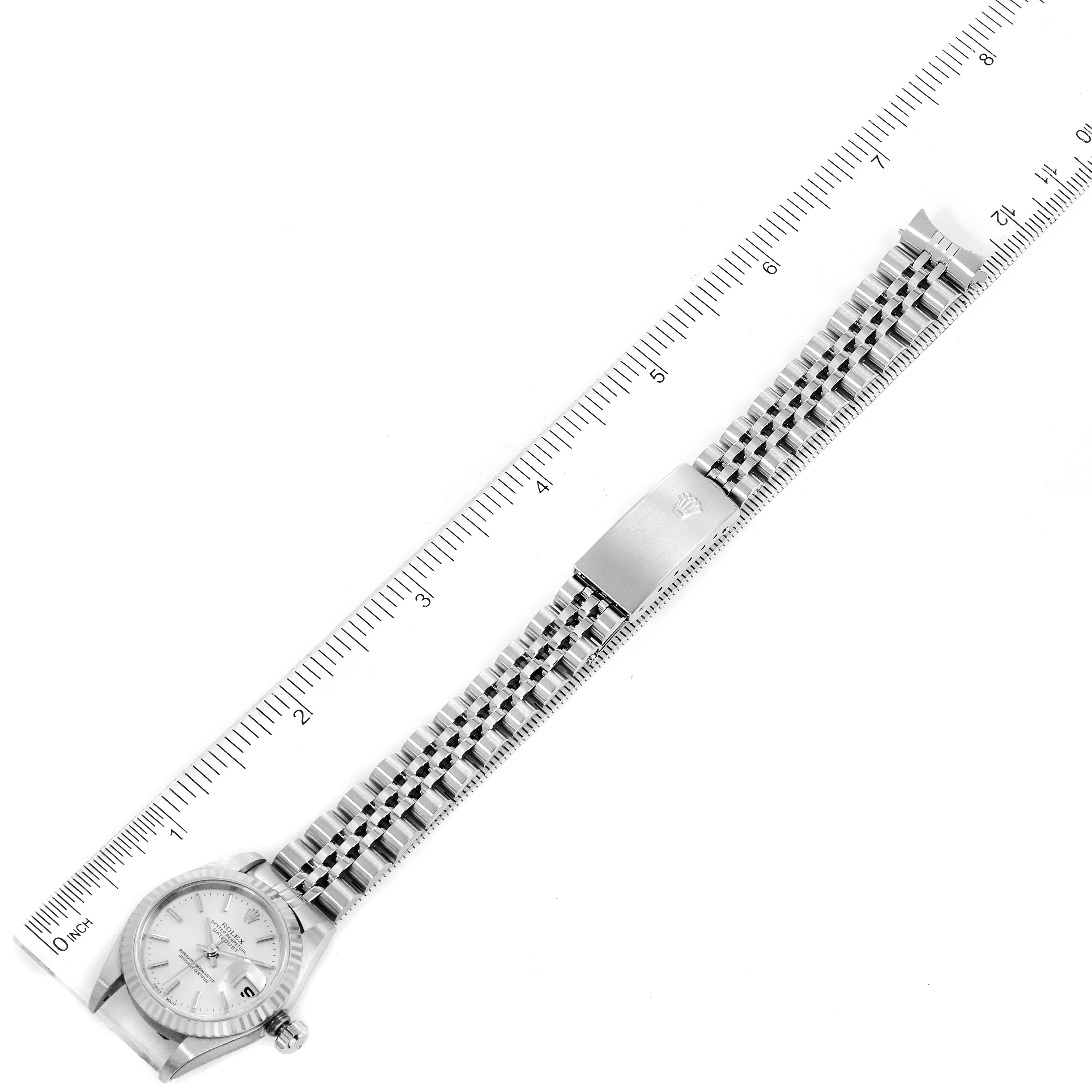 The image shows a top-down view of a Rolex Datejust 79174 Women
s Stainless Steel Silver Dial 79174 Women
s Stainless Steel Silver Dial watch, highlighting the dial, case, and entire bracelet, with a ruler for scale.