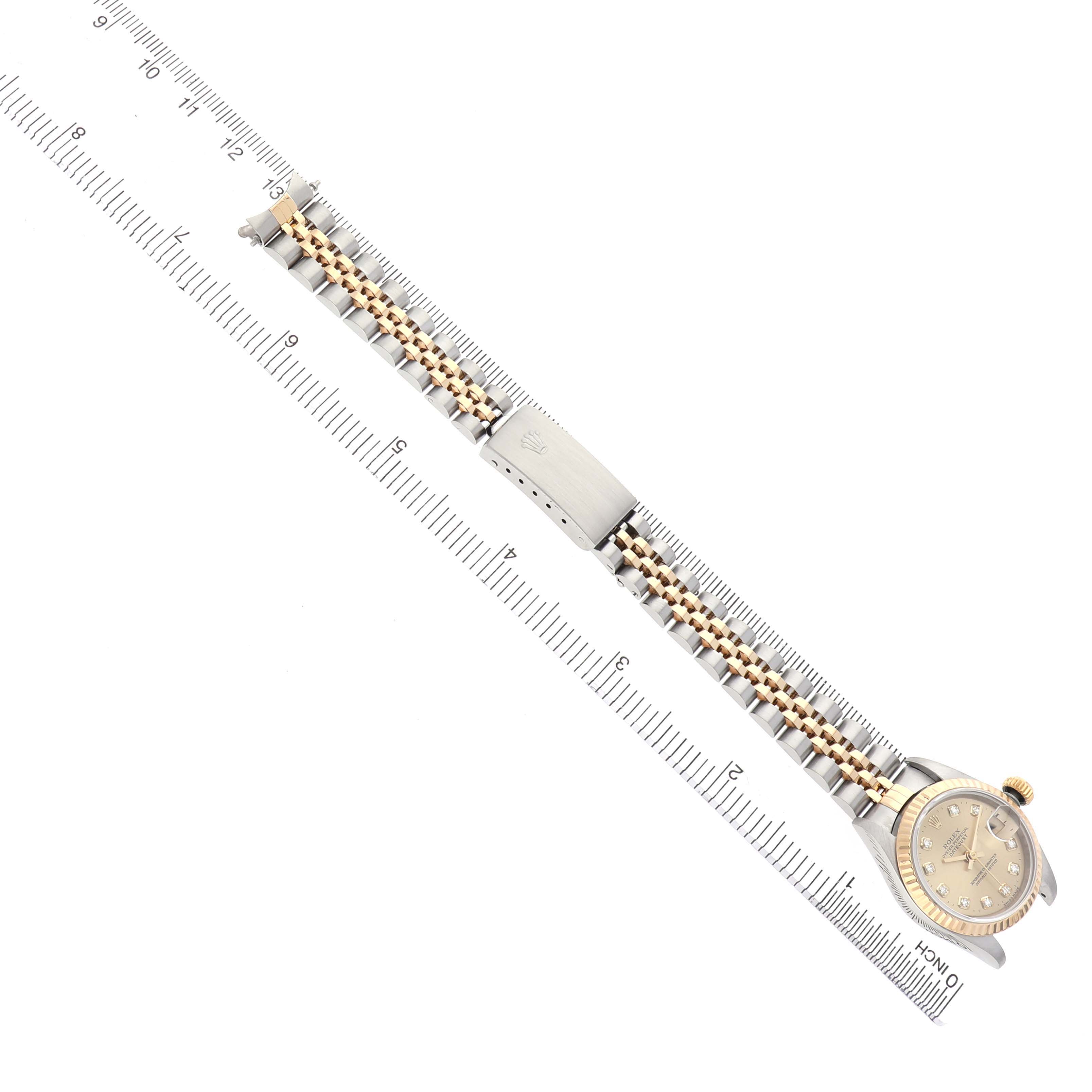 The Rolex Datejust 69173 Women's Stainless Steel Champagne Dial watch is shown from a top-down angle, displaying the bracelet and clasp alongside a ruler for scale.