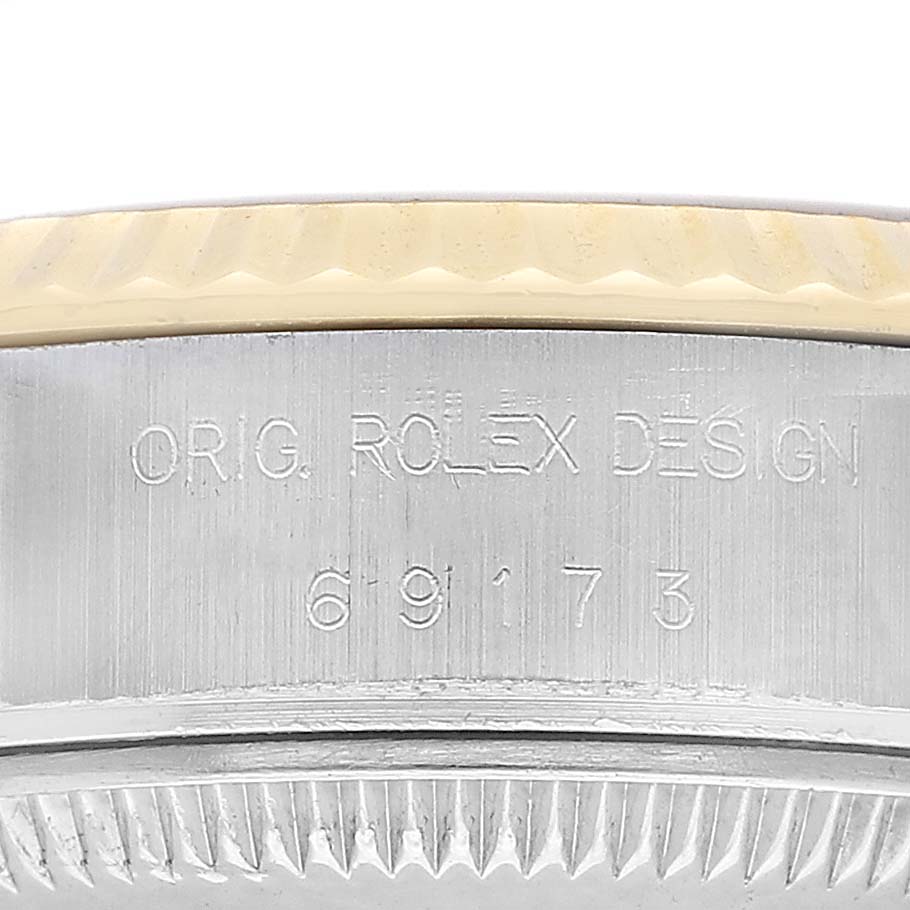 The image shows a close-up of the side of a Rolex Datejust 69173 Women's Stainless Steel Champagne Dial watch, featuring the serial number and "ORIG. ROLEX DESIGN" engraving.