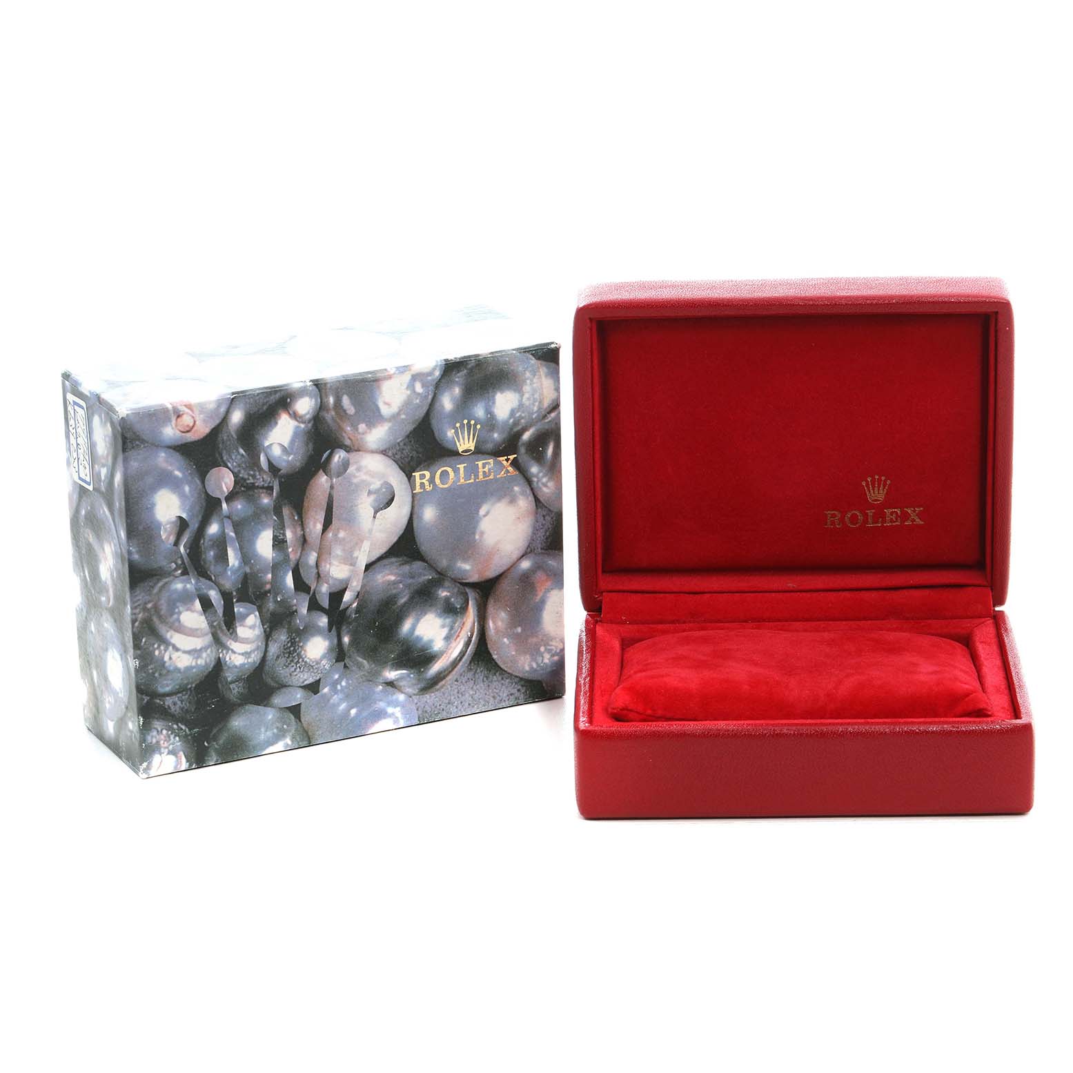 The image shows an open red Rolex box with a cushion inside, next to a Rolex-branded outer box, both viewed from the front.