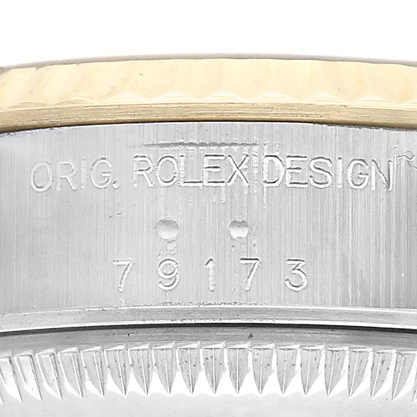 The image shows a close-up of the side of a Rolex Datejust 79173 Women's Steel and Gold (two tone) Champagne Dial, focusing on the model number and design engraving.