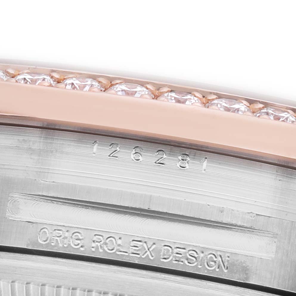 The image shows a close-up of the engraving and diamond-set bezel of a Rolex Datejust 126281 Men's Steel and Gold (two tone) Pink Dial watch.