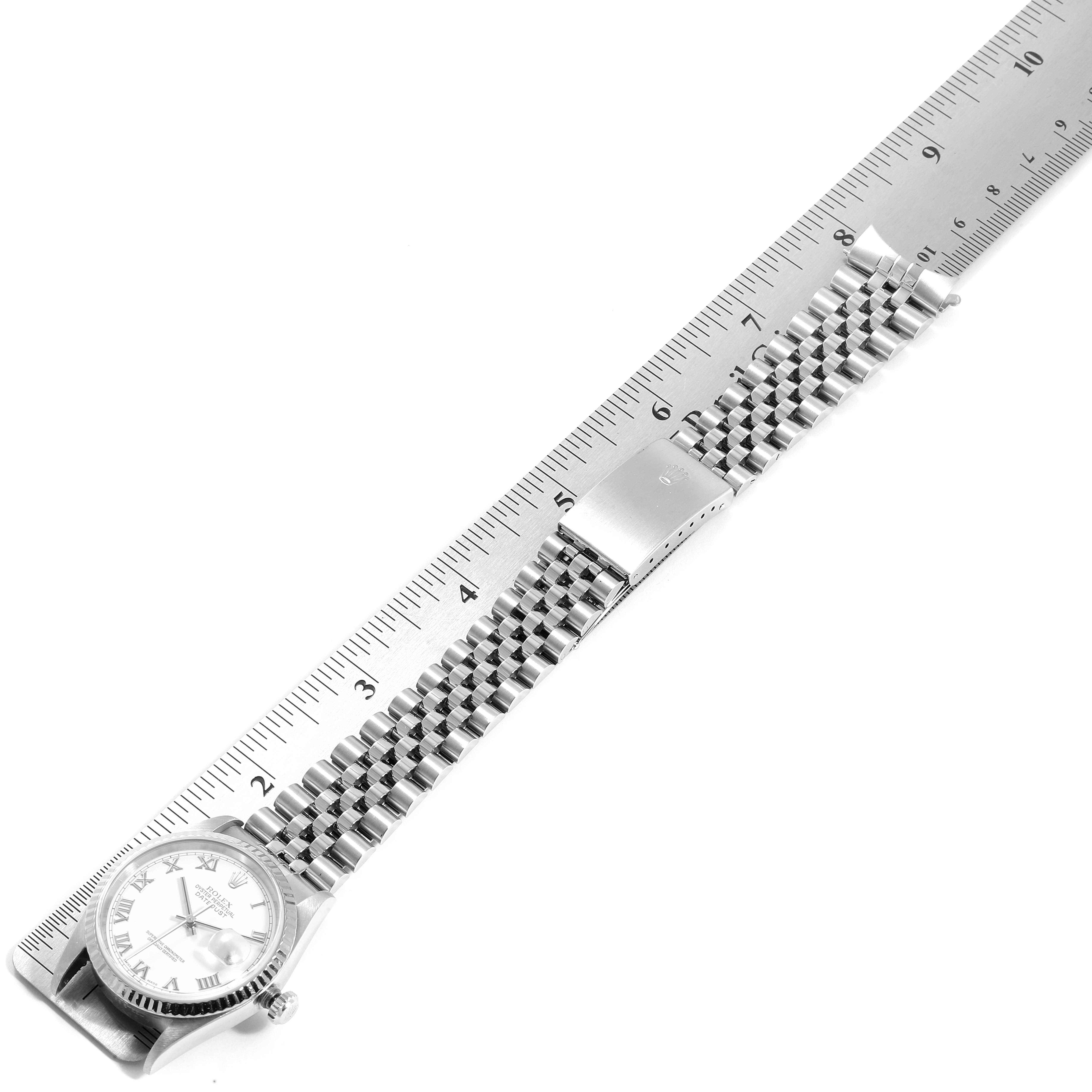 The Rolex Datejust 16234 Men's Stainless Steel White Dial 16234 Men's Stainless Steel White Dial watch is shown from a top-down angle alongside a ruler, displaying its bracelet and clasp.