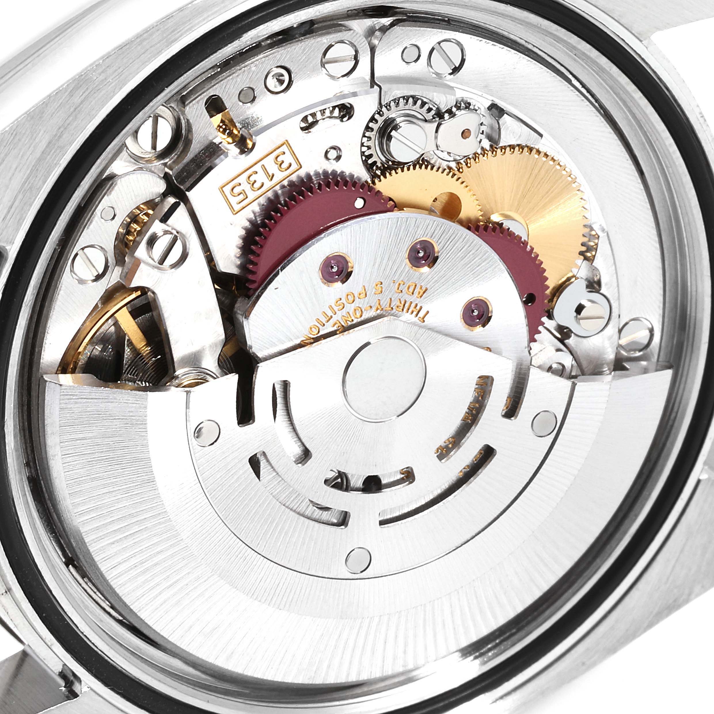 The image shows a close-up view of the Rolex Datejust 116234 Men's Stainless Steel Silver Dial 116234 Men's Stainless Steel Silver Dial movement, featuring gears and mechanical components.