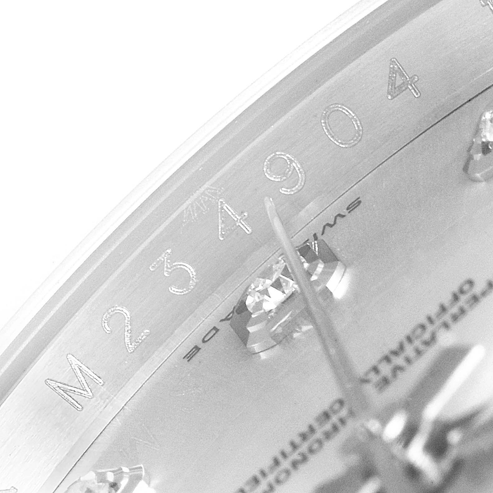 This close-up image of the Rolex Datejust 116234 Men's Stainless Steel Silver Dial 116234 Men's Stainless Steel Silver Dial model shows the serial number and part of the dial with diamond markers.