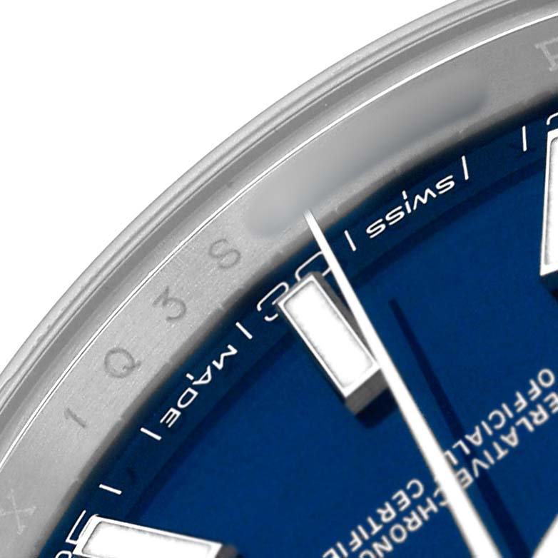 The close-up image shows part of the dial and edge of the bezel of a Rolex Datejust 41 126300 Men's Stainless Steel Blue Dial, highlighting the markers and text.