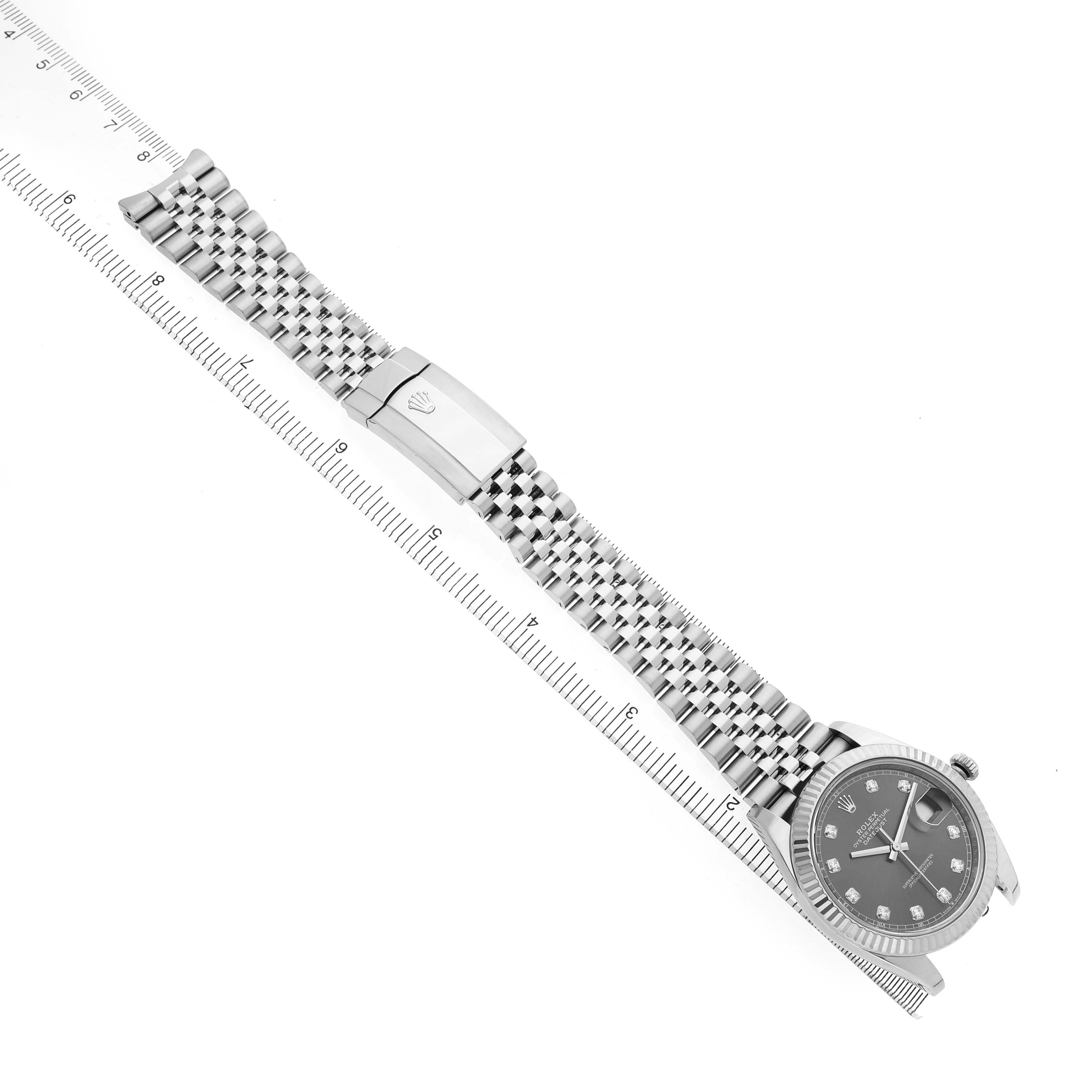 The Rolex Datejust 41 126334 Men's Stainless Steel Grey Dial watch is shown from above, displaying the bracelet, clasp, and face alongside a measuring ruler.