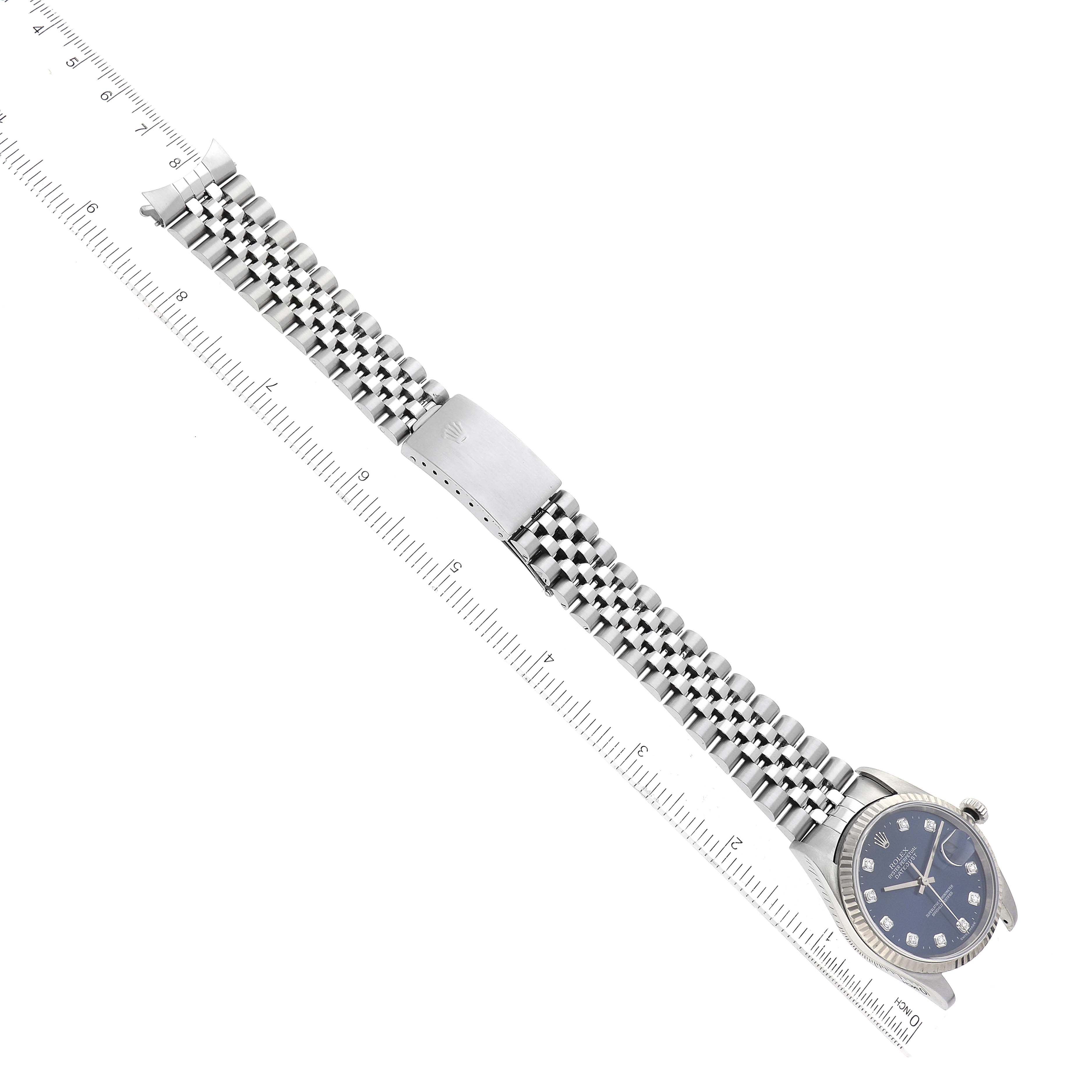 This image shows the entire Rolex Datejust 16234G Men's Stainless Steel Blue Dial 16234G Men's Stainless Steel Blue Dial watch laid flat, highlighting the bracelet, clasp, and face, with a ruler for scale.