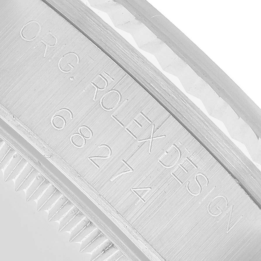 The image shows a close-up view of the engraved side of a Rolex Mid-Size 68274 Women's Stainless Steel Pink Dial model watch, highlighting the text and edge detailing.