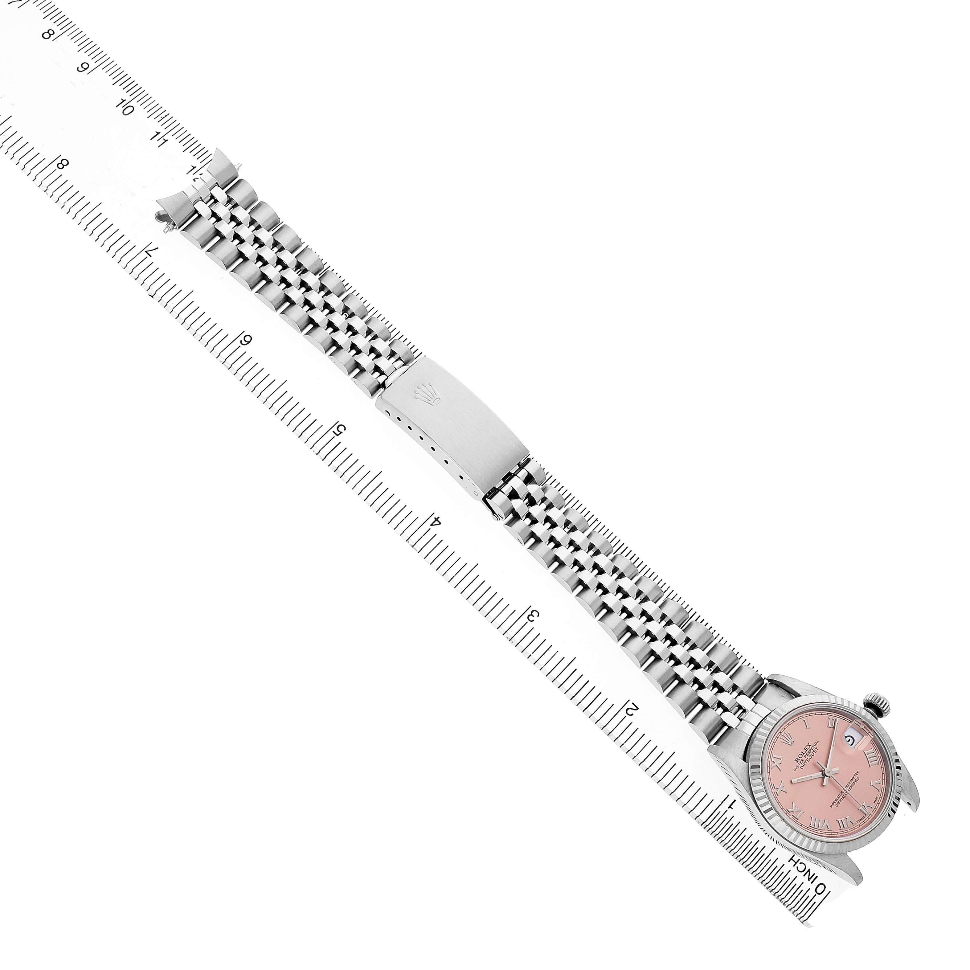 The Rolex Mid-Size 68274 Women's Stainless Steel Pink Dial watch is shown diagonally with a pink dial, bracelet, and clasp, alongside a ruler for scale.
