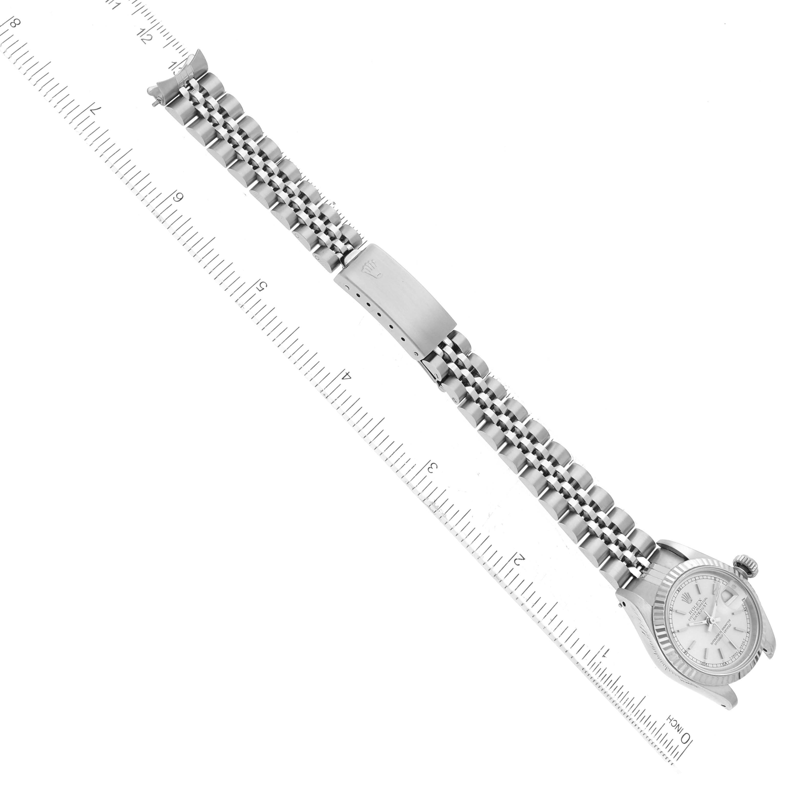 The image shows a full view of a Rolex Datejust 69174 Women
s Stainless Steel Silver Dial 69174 Women
s Stainless Steel Silver Dial watch laid flat, with the ruler measuring the length of the watch and its bracelet.