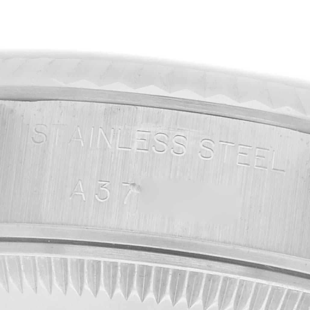 The image shows the side of a Rolex Datejust 79174 Women
s Stainless Steel Silver Dial 79174 Women
s Stainless Steel Silver Dial watch, focusing on the engraved stainless steel and part of the fluted bezel.