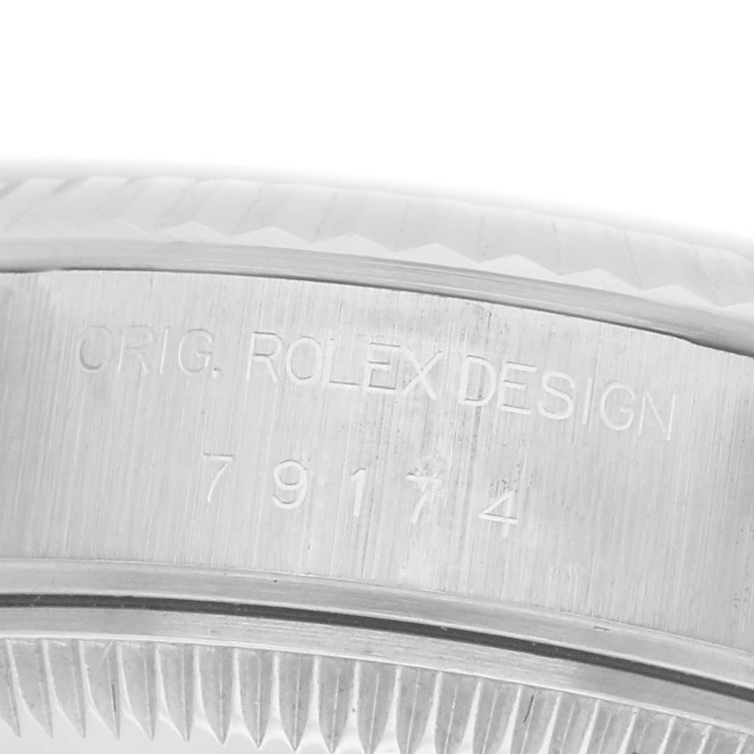 The image shows a close-up of the engraved side of the Rolex Datejust 79174 Women
s Stainless Steel Silver Dial 79174 Women
s Stainless Steel Silver Dial watch case with its serial number.