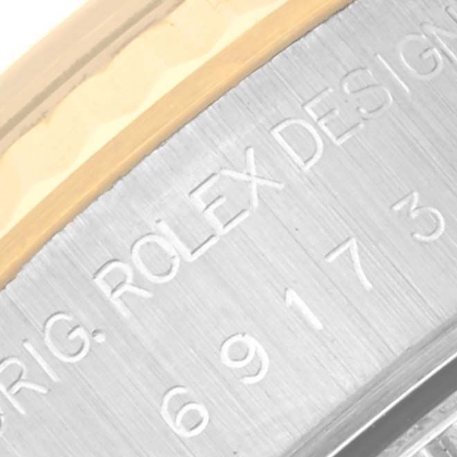 This close-up image shows part of the case side engraving with "ORIG. ROLEX DESIGN" on a Rolex Datejust 69173 Women's Steel and Gold (two tone) Silver Dial 69173 Women's Steel and Gold (two tone) Silver Dial watch.