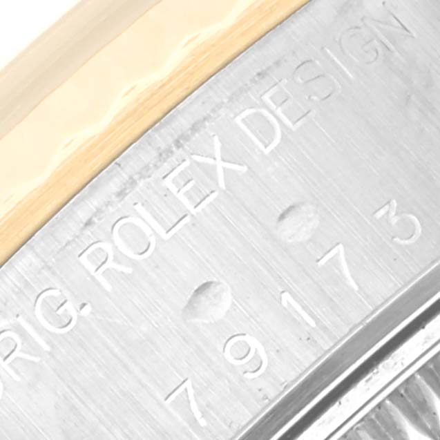 This close-up image shows the engraved model number and part of the bezel of a Rolex Datejust 79173 Women
s Steel and Gold (two tone) Mother of Pearl Dial 79173 Women
s Steel and Gold (two tone) Mother of Pearl Dial watch.