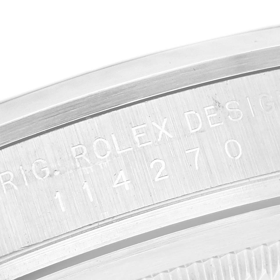 The image shows a close-up of the engraved side of the Rolex Explorer 114270 Men's Stainless Steel Black Dial 114270 Men's Stainless Steel Black Dial's case.